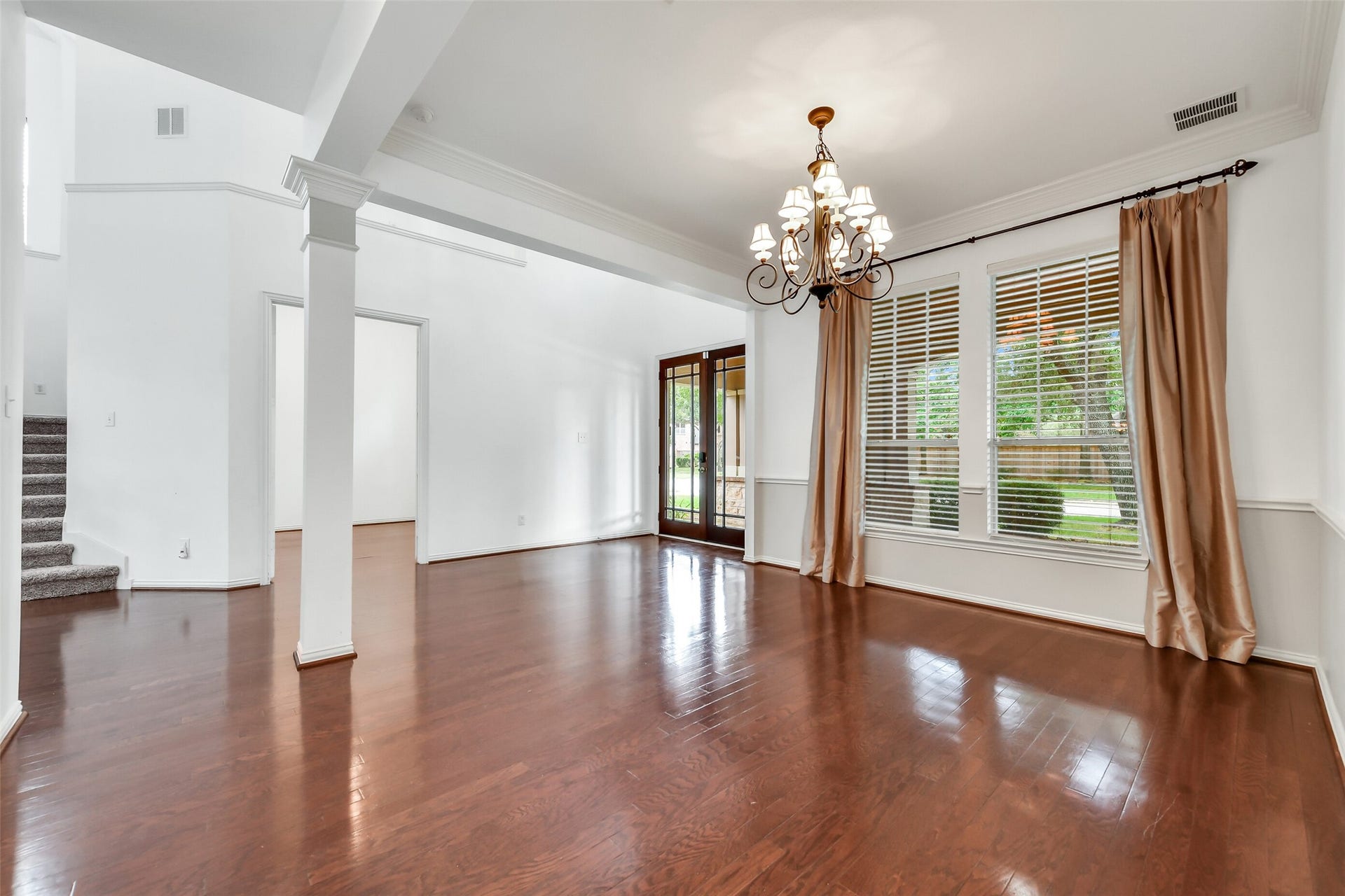 8407 Alyssa Gardens Lane, Humble, TX 77396 This view of the formal dining room highlights designer chandelier, custom drapery, and window blinds, with open doors leading seamlessly into the first-floor office