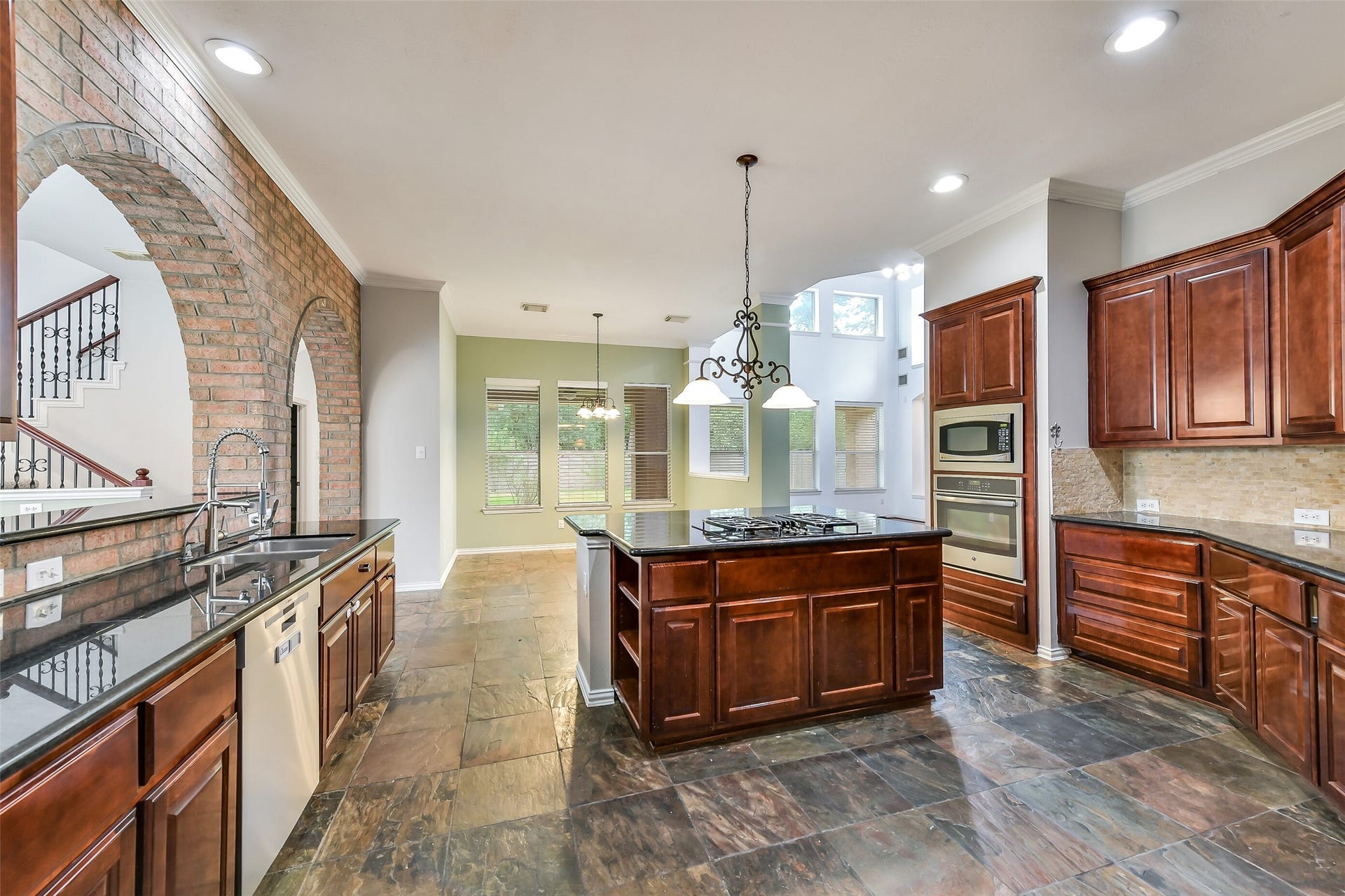 8407 Alyssa Gardens Lane, Humble, TX 77396 This view highlights the kitchen's stainless steel appliances, extra island storage, and an adjacent breakfast nook with views of the backyard.