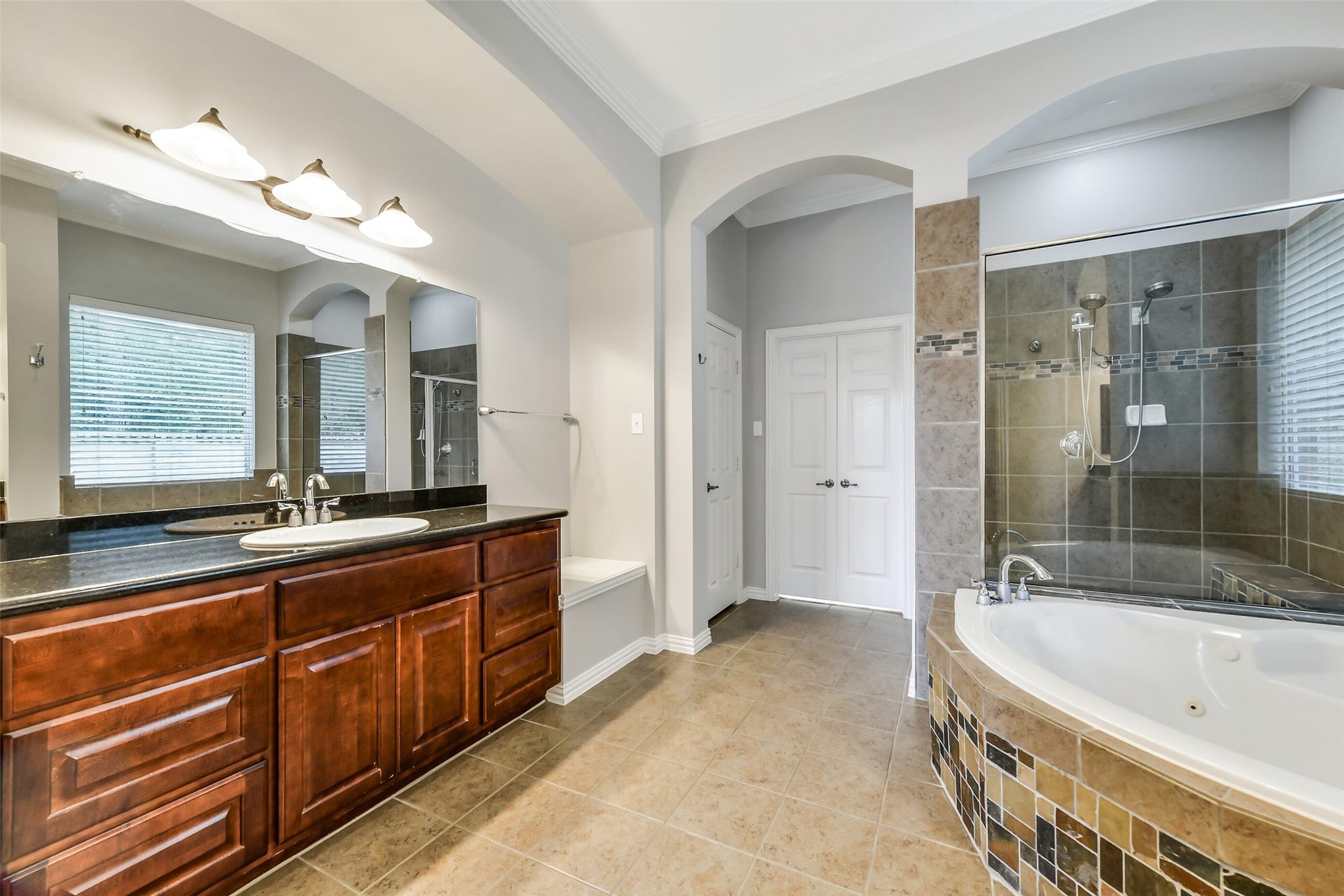 8407 Alyssa Gardens Lane, Humble, TX 77396 The spa-like primary bathroom boasts dual sinks and vanities, a relaxing soaking tub, and a spacious walk-in shower.