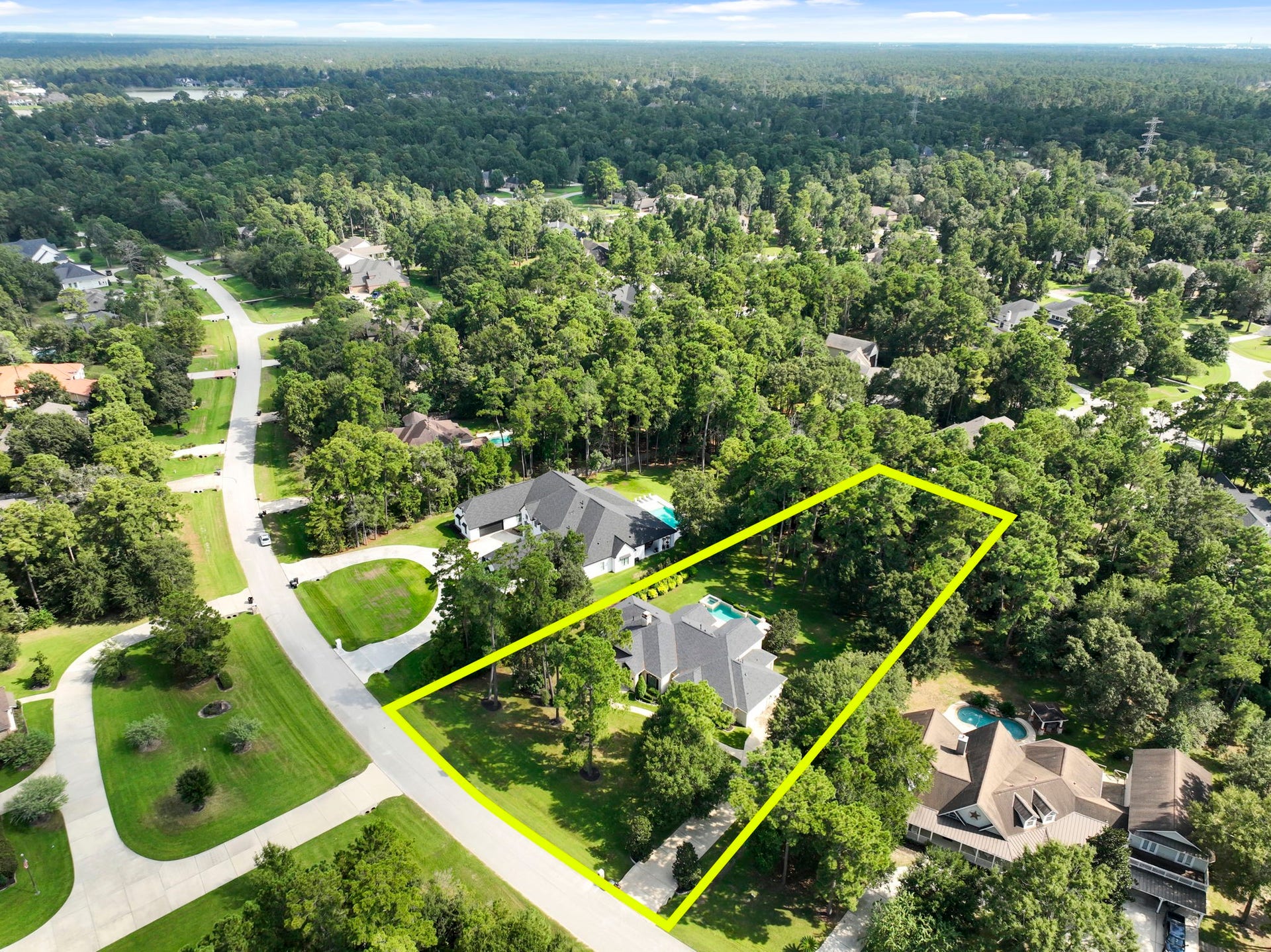 This bird's-eye perspective captures the full scope of the private, tree-shrouded lot, showcasing the pool, spa, and mature landscaping in relation to the home's footprint.