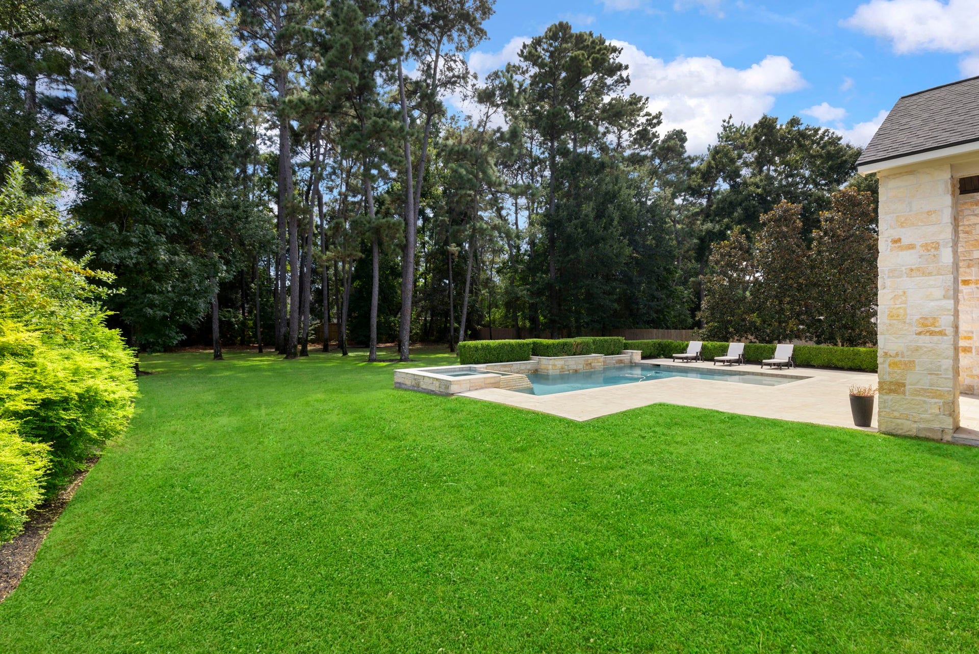 A peaceful, tree-lined setting surrounds the home, with towering pines offering shade and privacy across the expansive lot.