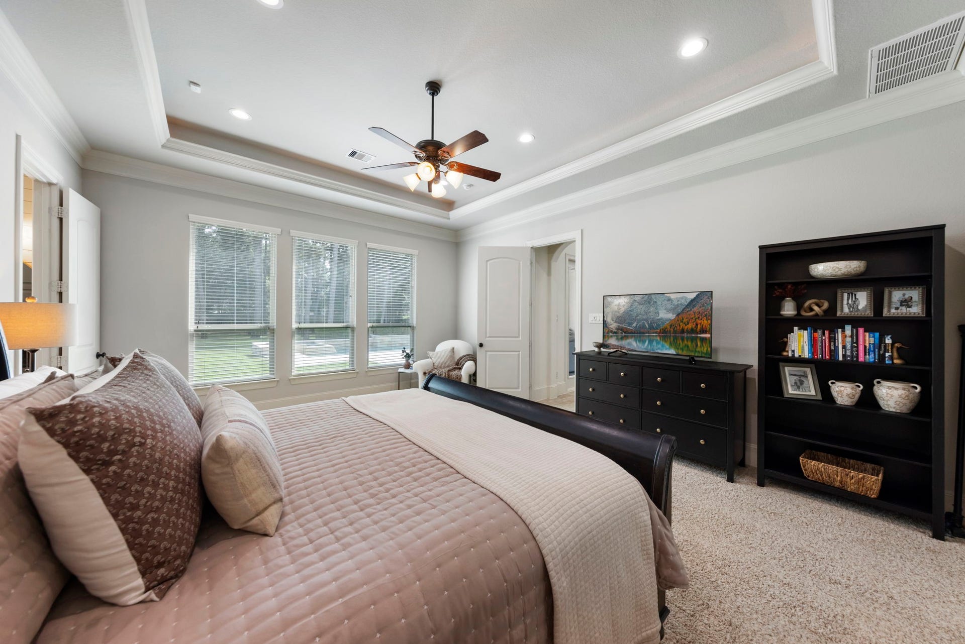 This vantage highlights the room's sheer scale, with tray-ceiling detailing overhead and a private view out to the pool and grounds beyond.