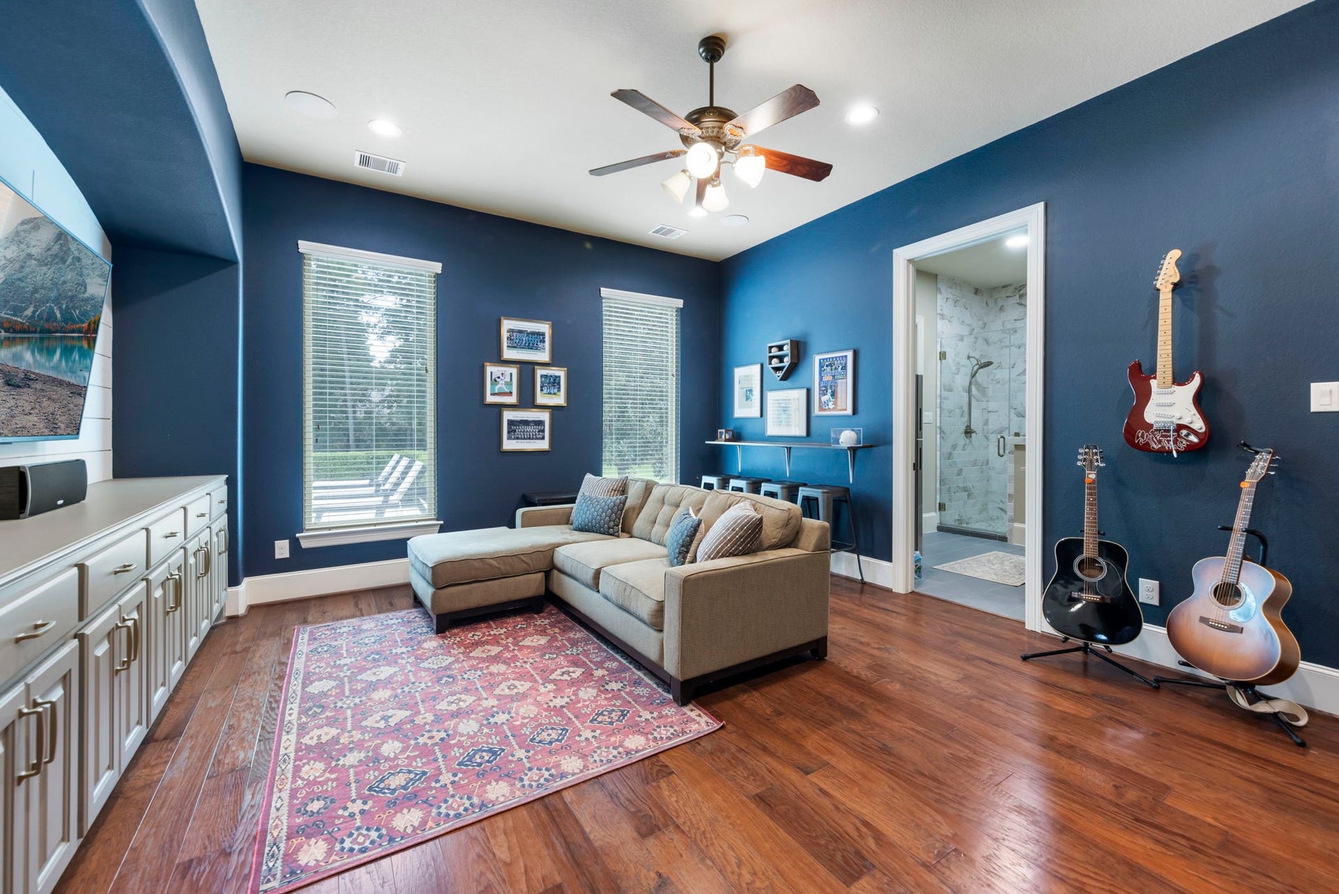 Bold navy walls set a dramatic backdrop for this versatile bonus room, complete with a private en-suite bath for added everyday convenience.