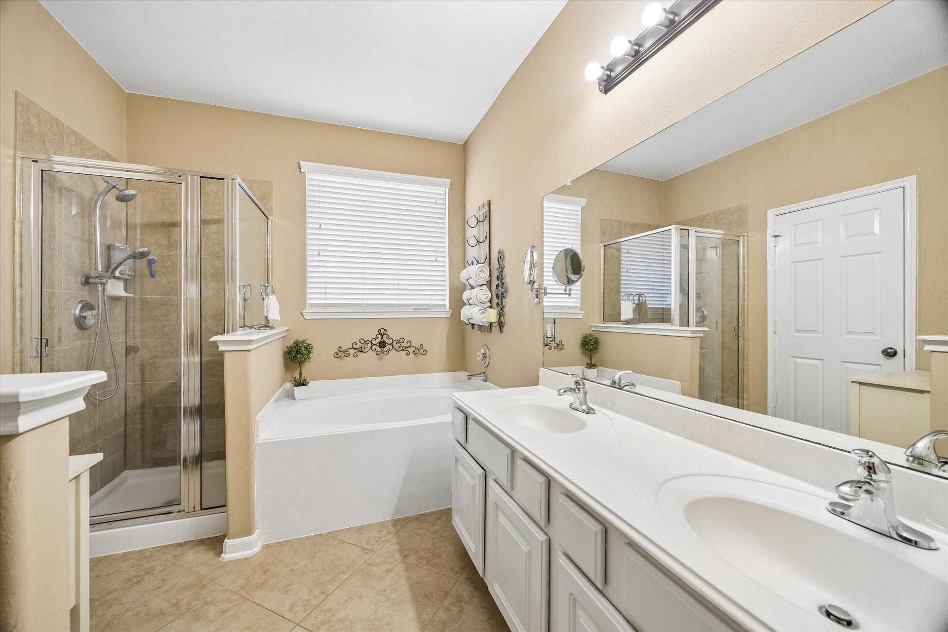 13918 Cypress Creek Bank Drive, Cypress, TX 77429 The primary bathroom offers a spacious dual-sink vanity, soaking tub, and separate glass-enclosed shower. Natural light and generous counter space make morning routines feel effortless.