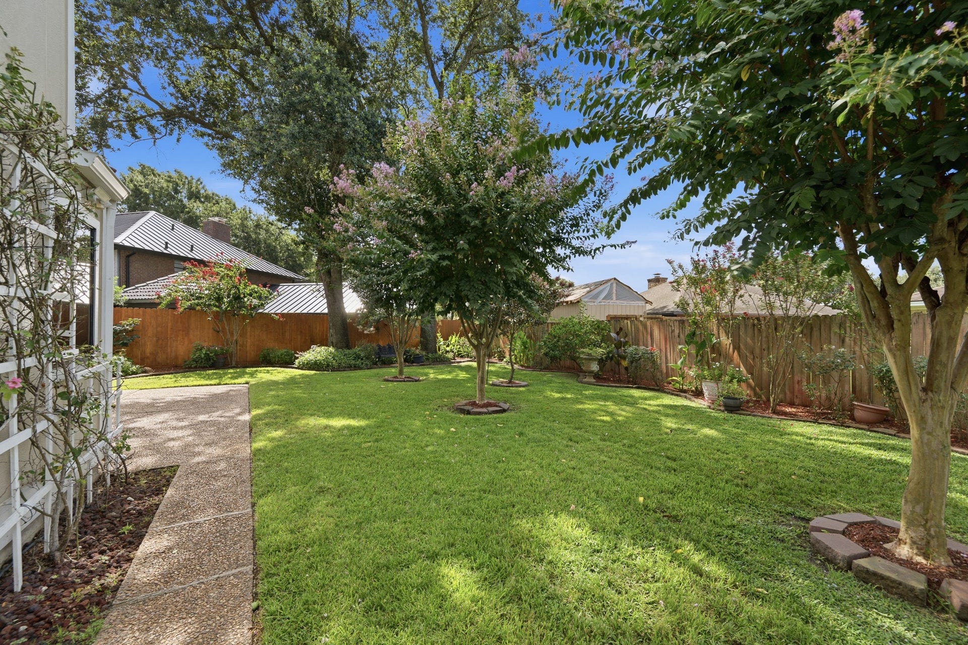Expansive backyard surrounded by mature trees and established landscaping.