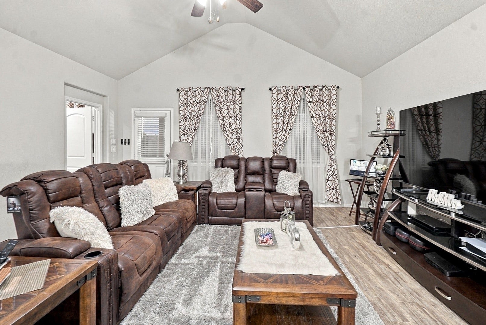 18042 Atwood Mill Drive, New Caney, TX 77357 Spacious living room with vaulted ceiling, ceiling fan, abundant natural light, and easy access to the backyard.