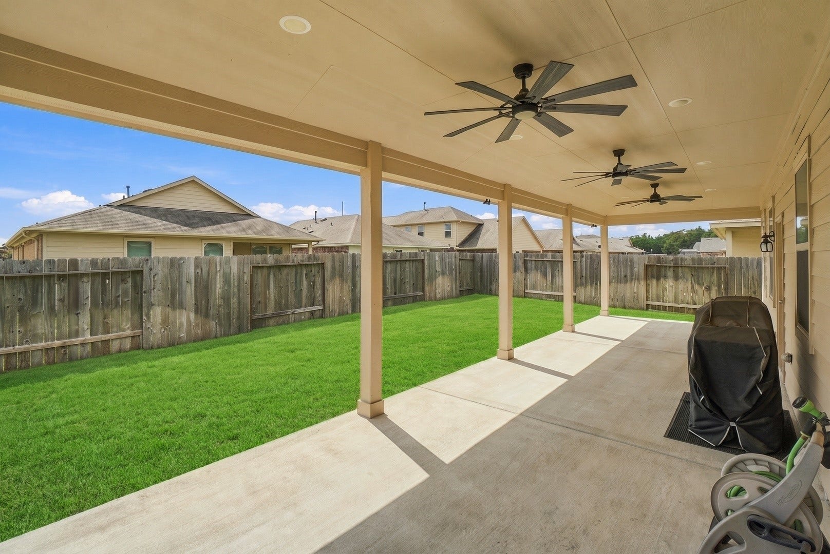 18042 Atwood Mill Drive, New Caney, TX 77357 Additional view of the extended covered patio showing its depth and open layout, with multiple ceiling fans for added comfort.