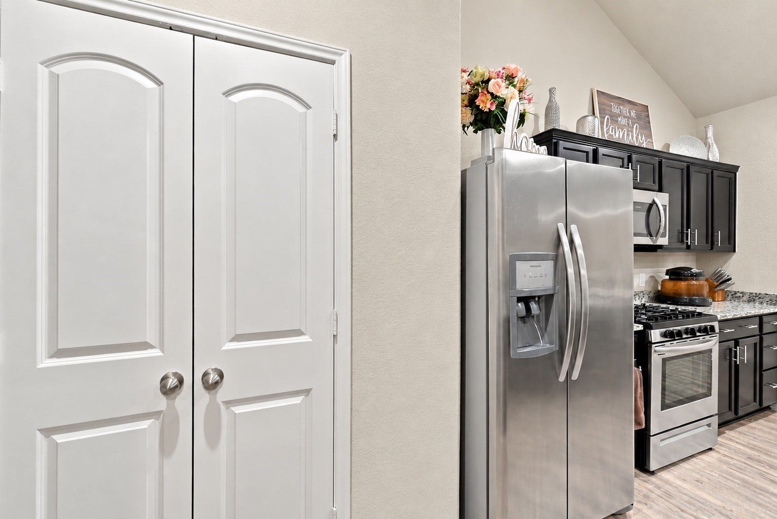 18042 Atwood Mill Drive, New Caney, TX 77357 Kitchen & Pantry
Kitchen view featuring stainless steel appliances, dark cabinetry, granite countertops, gas range, and convenient double-door pantry.