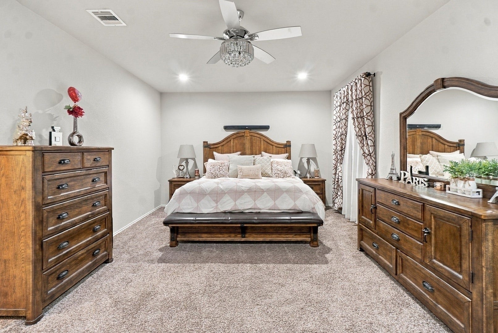 18042 Atwood Mill Drive, New Caney, TX 77357 The spacious primary suite features neutral finishes, recessed lighting, plush carpet, and a decorative ceiling fan.