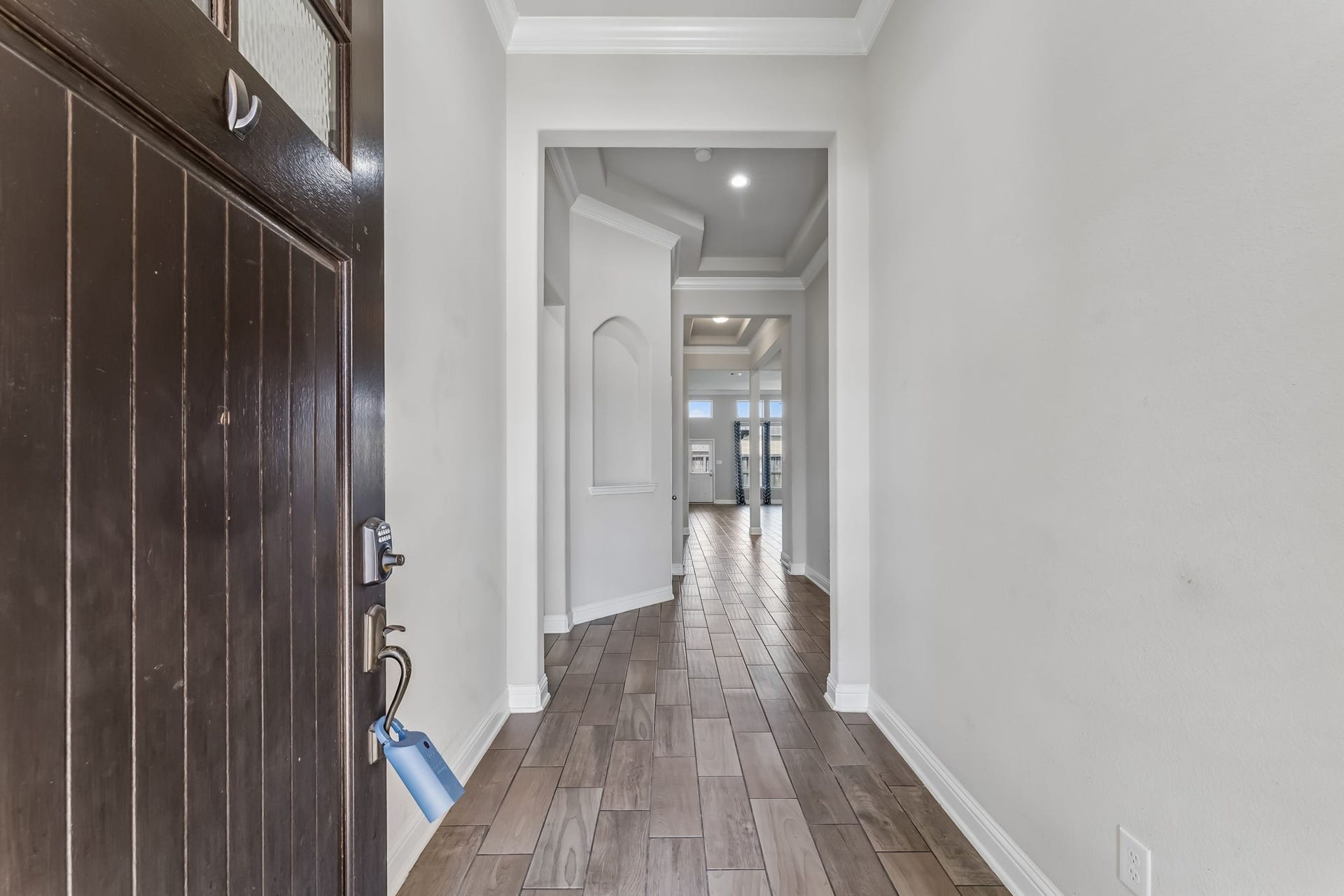 5107 Baroness Lane, Katy, TX 77493 Inviting entryway with elegant wood flooring and high ceilings, leading to an open and spacious living area.