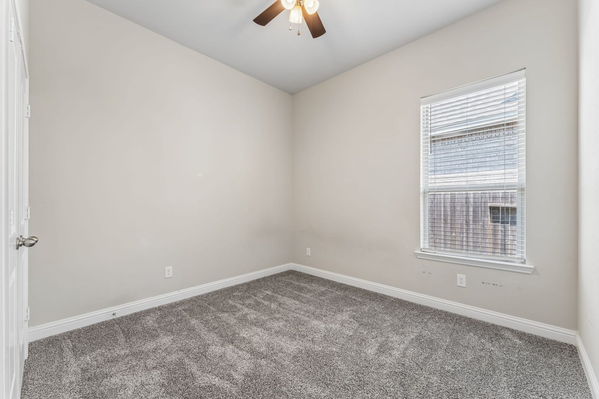 5107 Baroness Lane, Katy, TX 77493 Cozy bedroom with soft carpeting, neutral walls, and a ceiling fan, filled with natural light from a large window.