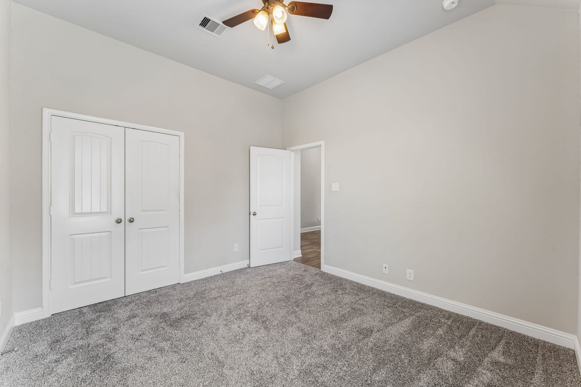 5107 Baroness Lane, Katy, TX 77493 Spacious bedroom with plush carpeting, neutral walls, and a ceiling fan, featuring dual closets for ample storage.