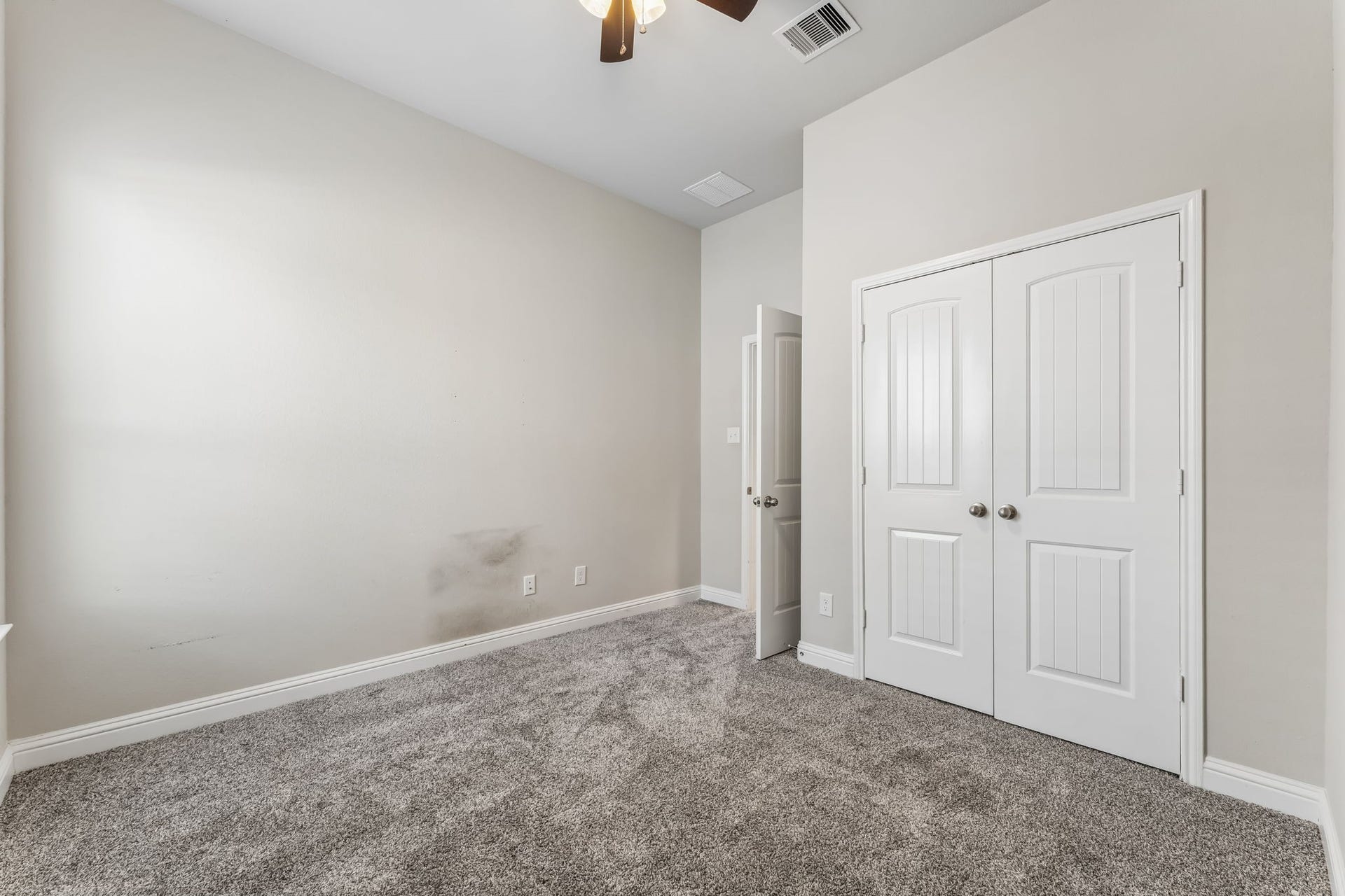 5107 Baroness Lane, Katy, TX 77493 Cozy bedroom featuring plush carpeting, neutral walls, and a spacious double-door closet, perfect for storage.