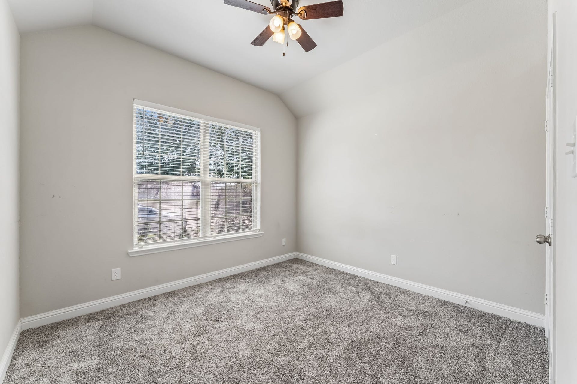 5107 Baroness Lane, Katy, TX 77493 Bright and airy bedroom featuring plush carpeting, a large window for natural light, and a ceiling fan for comfort.