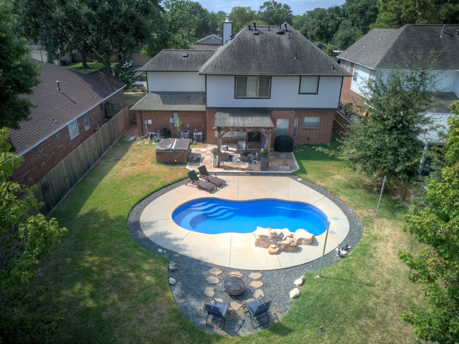 22510 Rangeview Drive, Katy, TX 77450 Stunning backyard oasis featuring a sparkling pool, spacious patio area with seating, and a cozy fire pit, perfect for entertaining and relaxation.