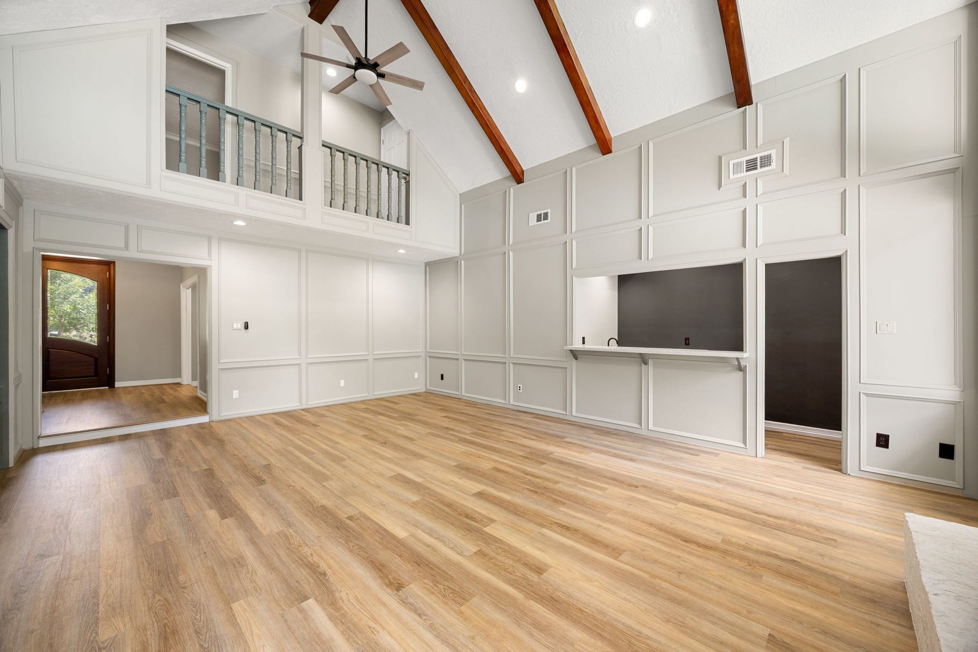 Dramatic cathedral ceilings and exposed beams create an impressive gathering space. Living room offers freshly painted paneled walls and an updated wet bar with wine chillers.