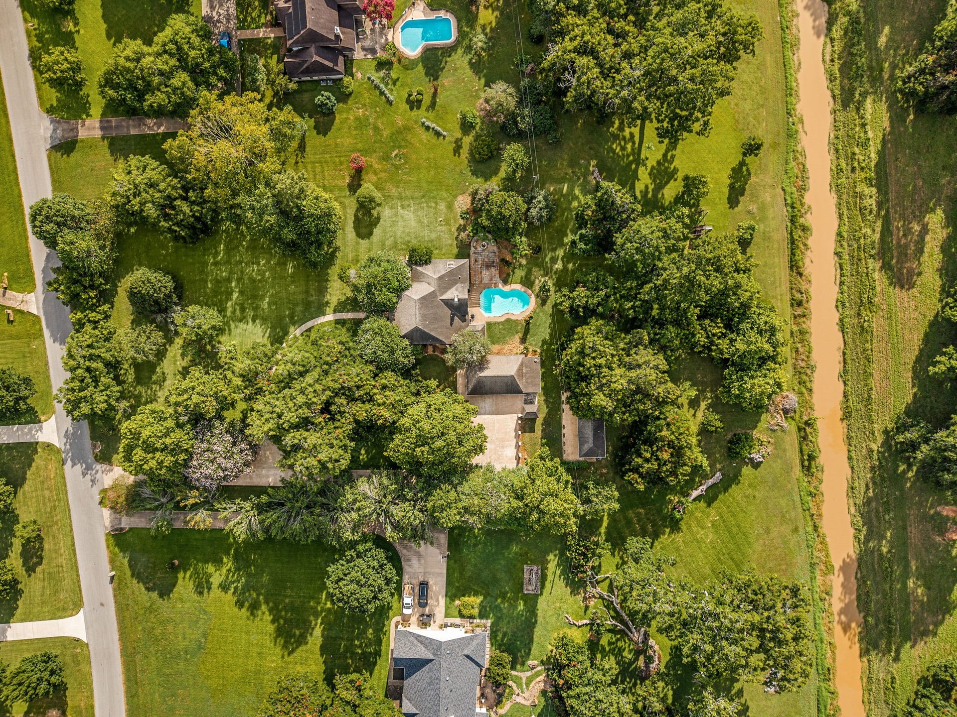 Bird's-eye view highlighting the 2.59-acre wooded homesite with bordering Jones Creek.