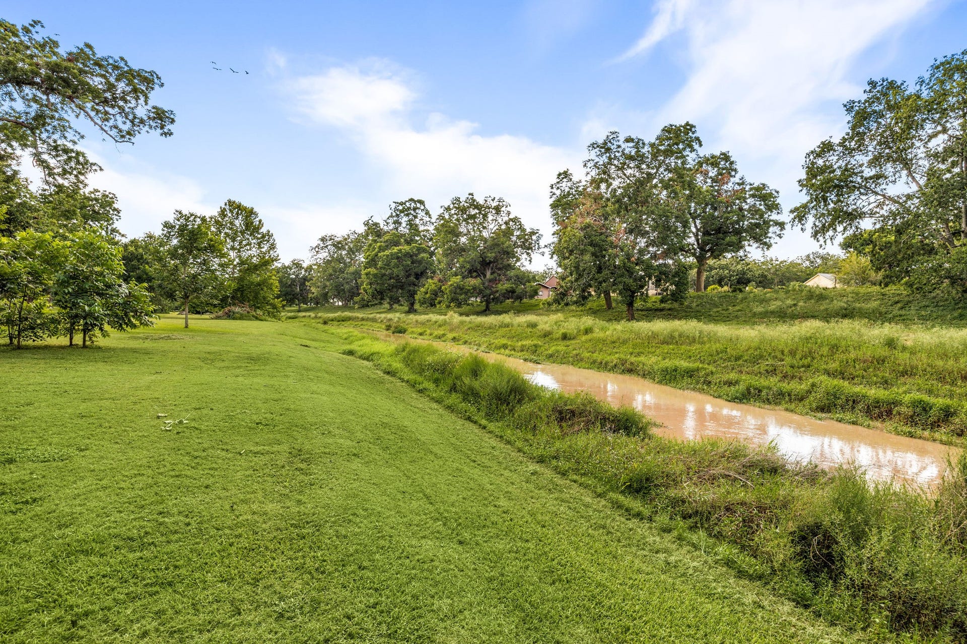 Scenic creek bordering the property adds natural beauty and privacy.