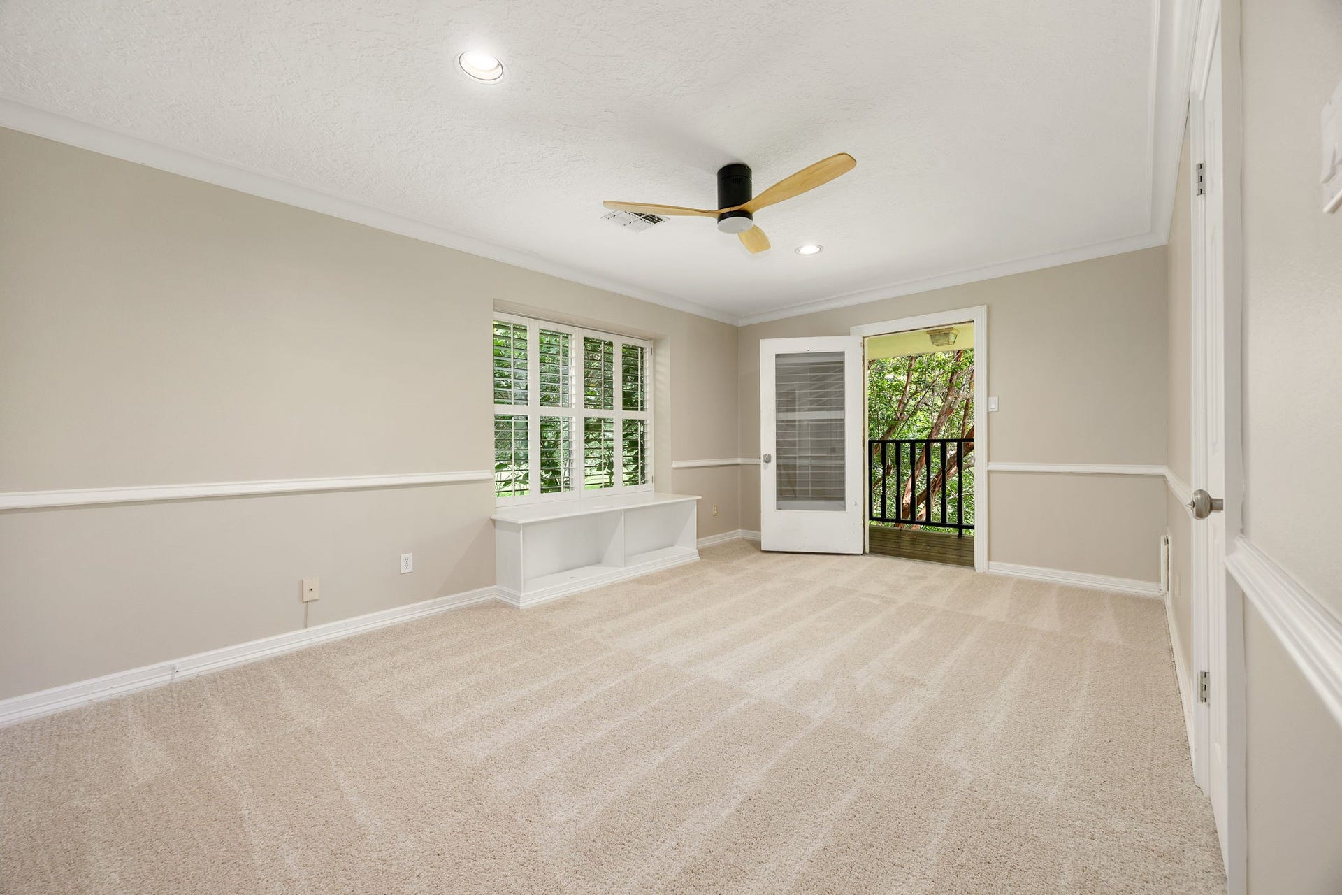 Secondary bedroom with views of the front yard through the charming balcony. Freshly painted with new carpet.