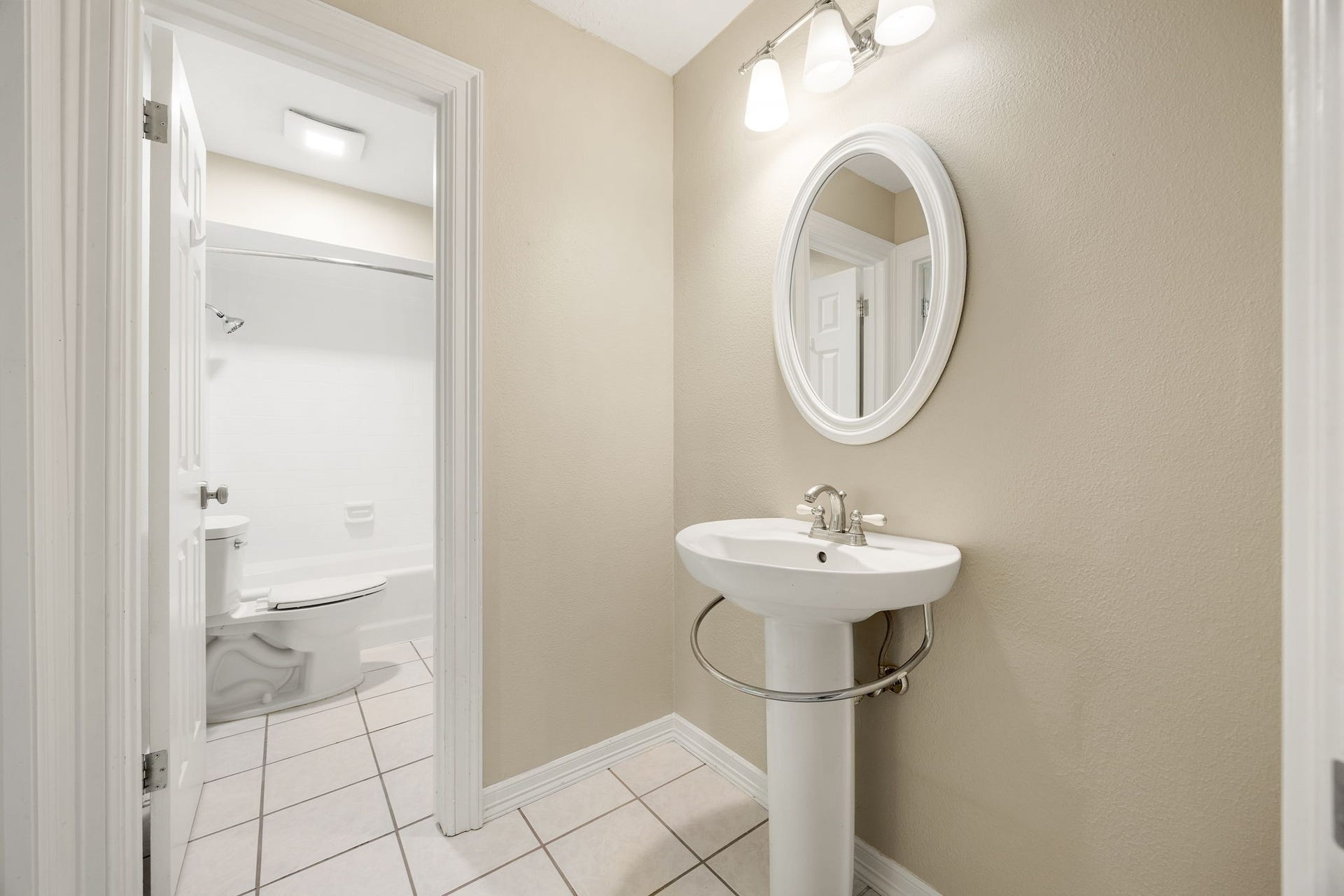 Jack-n-Jill style bathroom shared between two bedrooms upstairs. Both enjoy a pedestal sink of their own with a shared bathtub and toilet.