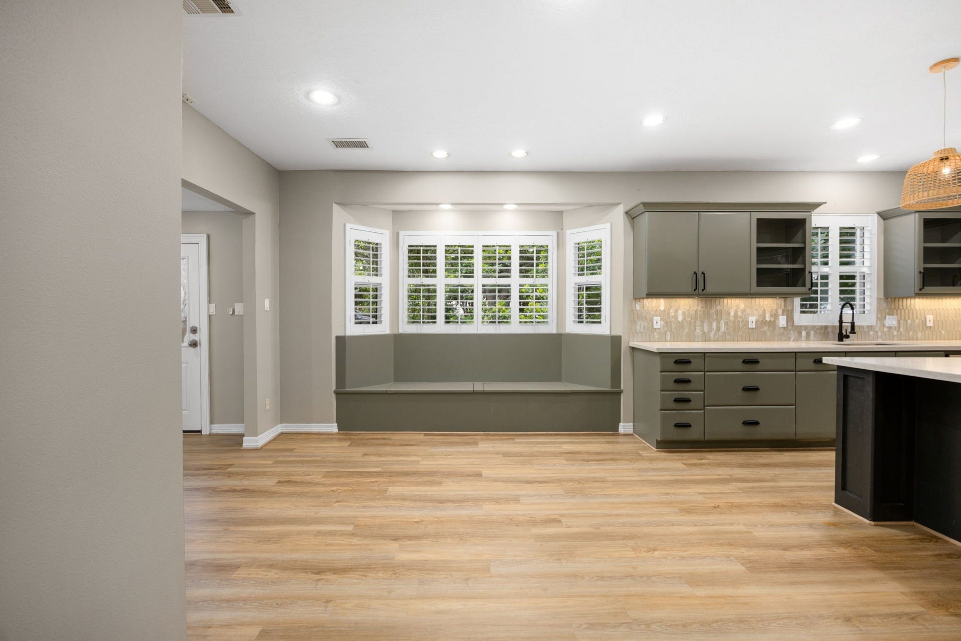 Sun-filled breakfast area featuring custom built-in bench seating and serene views of the wooded property.