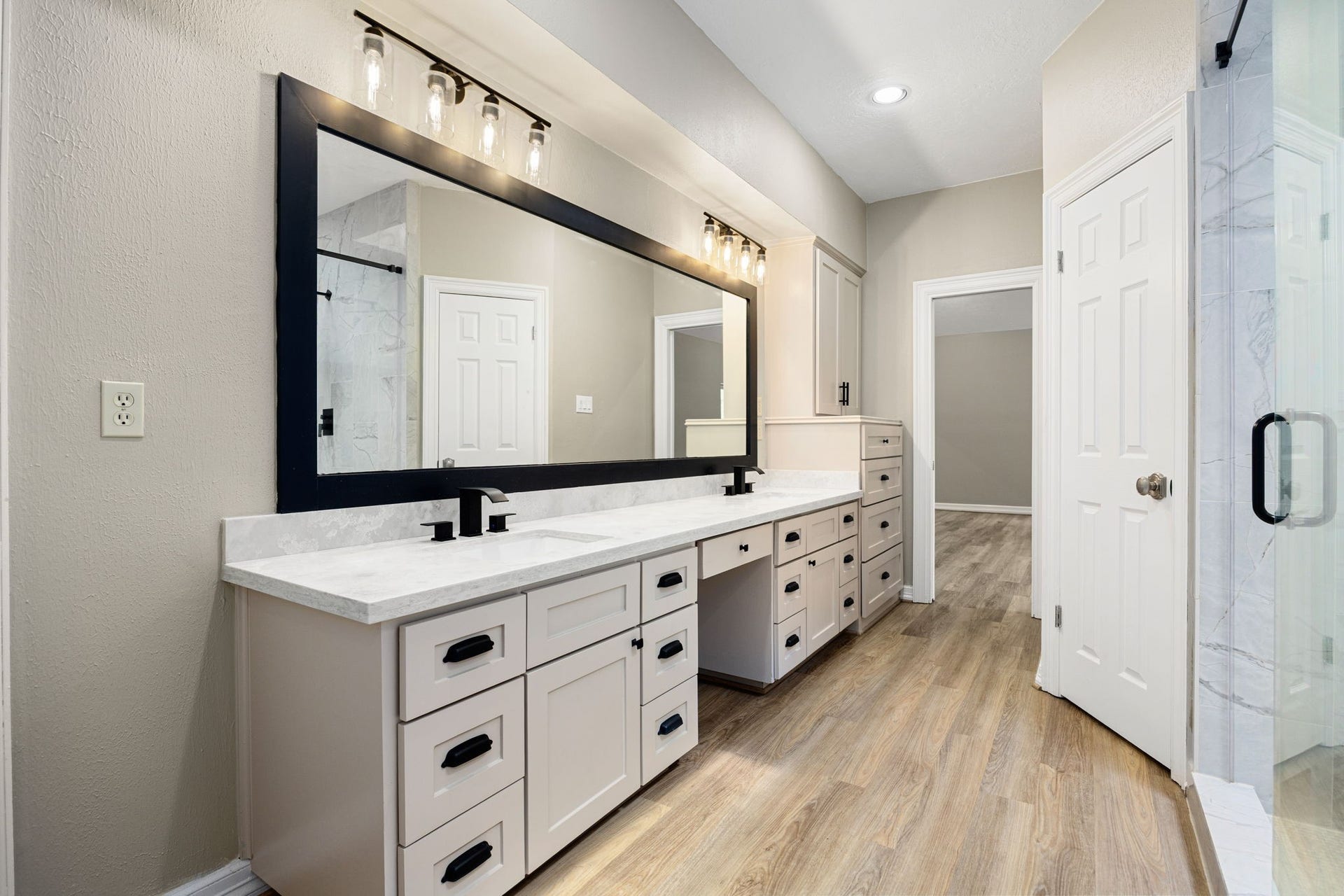 Spa-inspired primary bath featuring dual vanities with modern finishes. Two generously sized walk-in closets and a large walk-in shower with an added skylight.
