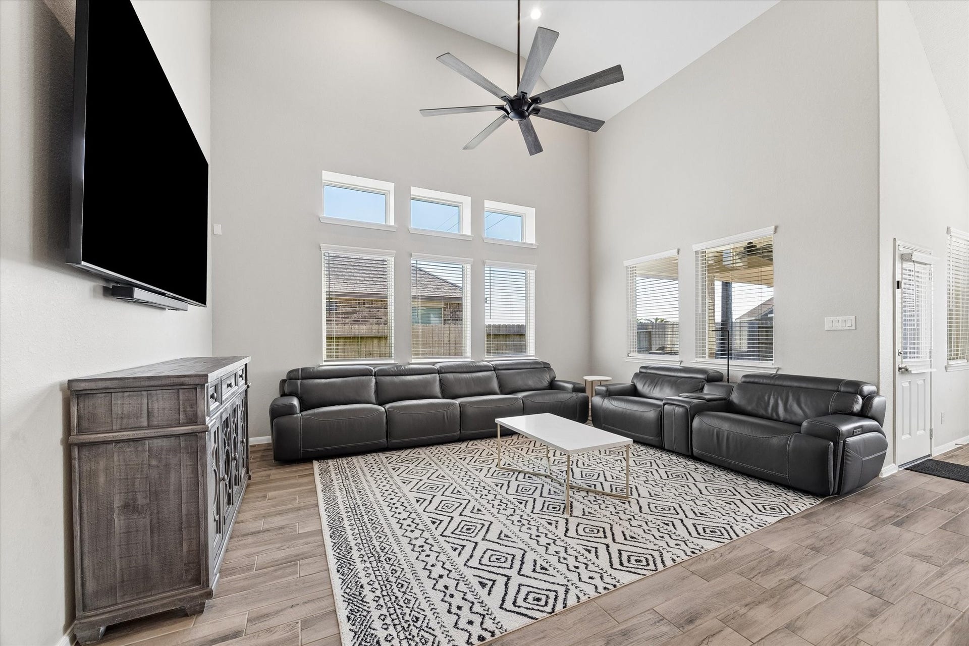14918 Lake Shore Avenue, Mont Belvieu, TX 77523 Stacked windows emphasize the living rooms impressive ceiling height, filling this comfortable gathering space with natural light.