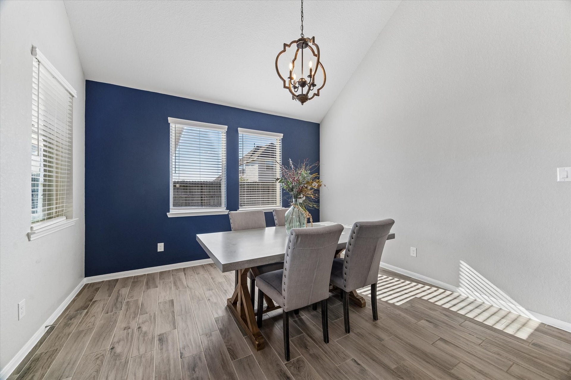 14918 Lake Shore Avenue, Mont Belvieu, TX 77523 A deep blue accent wall and statement chandelier give the dining room a distinctive backdrop for everyday meals and special celebrations.