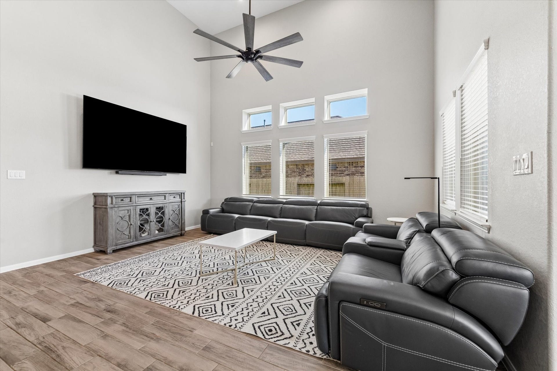 14918 Lake Shore Avenue, Mont Belvieu, TX 77523 Soaring ceilings, abundant natural light, and a spacious seating area make the living room an inviting place to gather.