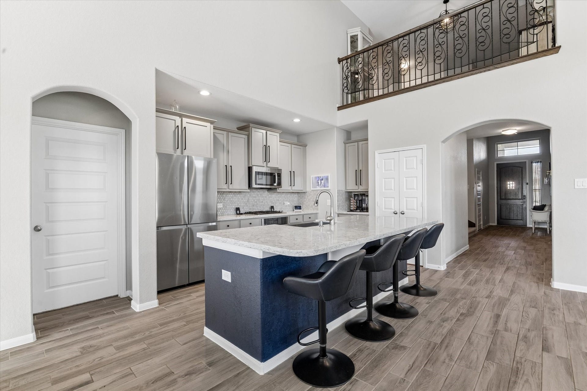 14918 Lake Shore Avenue, Mont Belvieu, TX 77523 The kitchen opens to the main gathering space beneath an upper-level overlook, bringing architectural interest to the homes central hub.