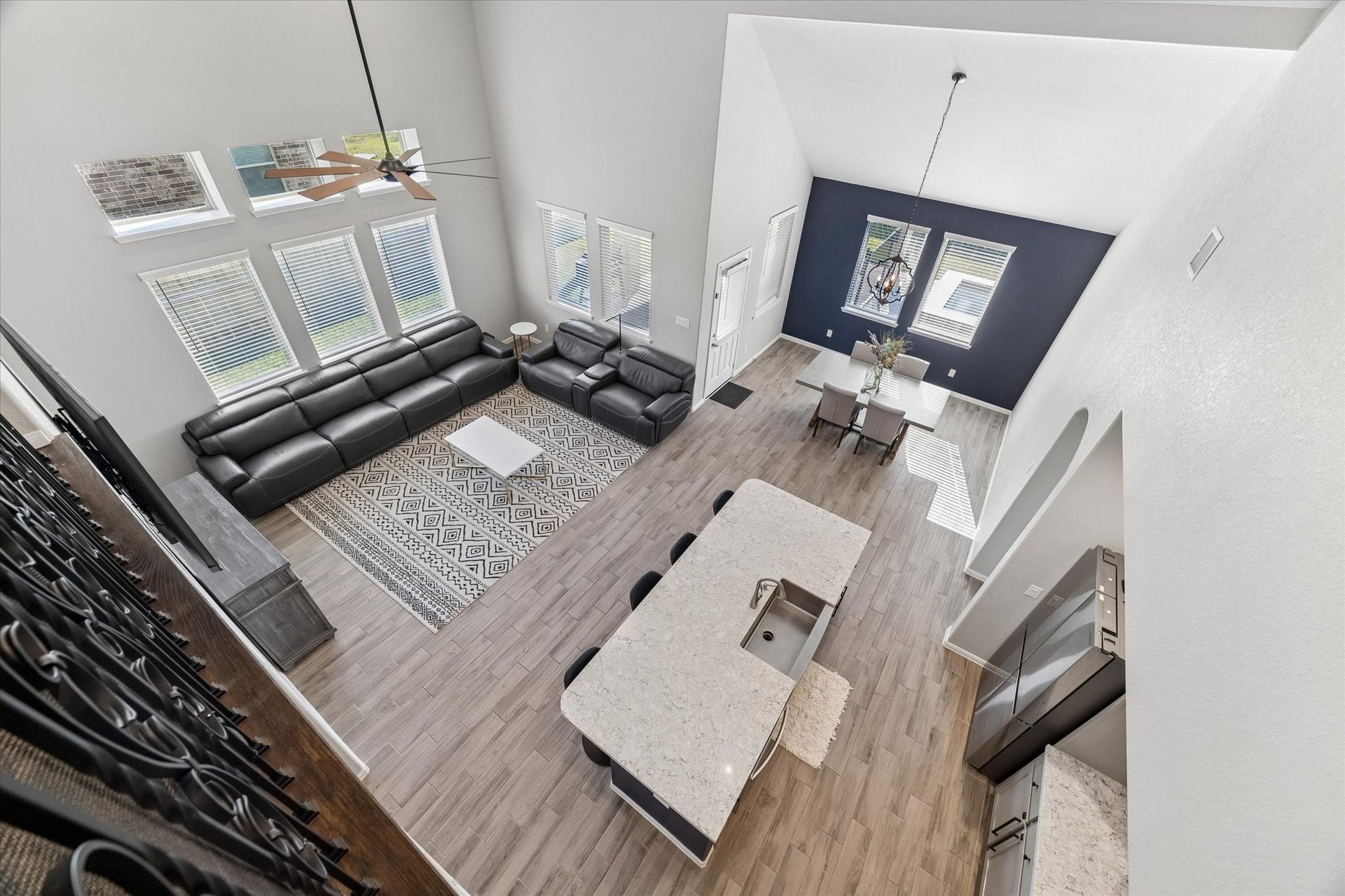 14918 Lake Shore Avenue, Mont Belvieu, TX 77523 This view from above showcases the connected living, kitchen, and dining areas, highlighting the homes open layout and dramatic ceiling height.