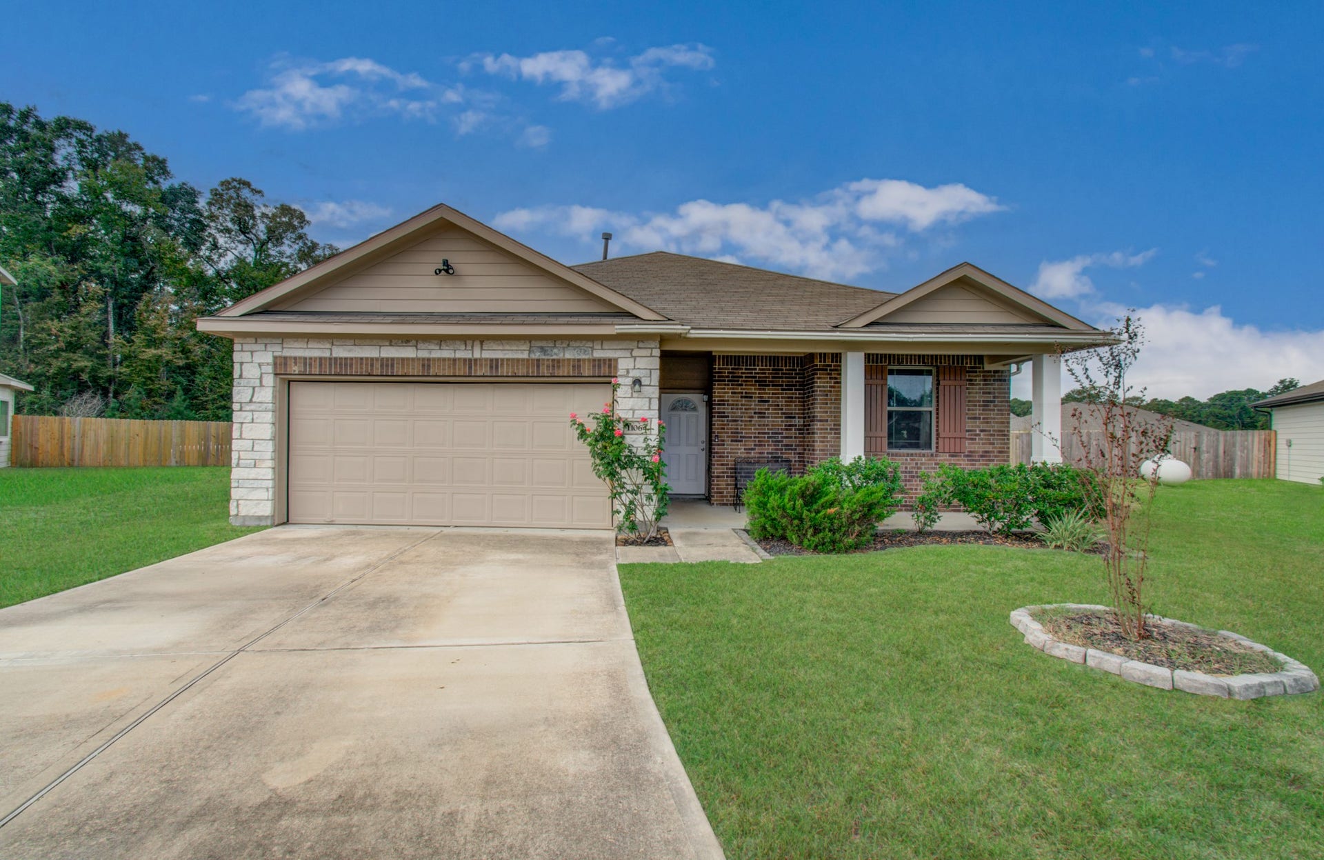 11064 Patriot Court, Cleveland, TX 77328 Charming single-story home with a welcoming front porch, two-car garage, and well-maintained landscaping, set on a spacious lot.