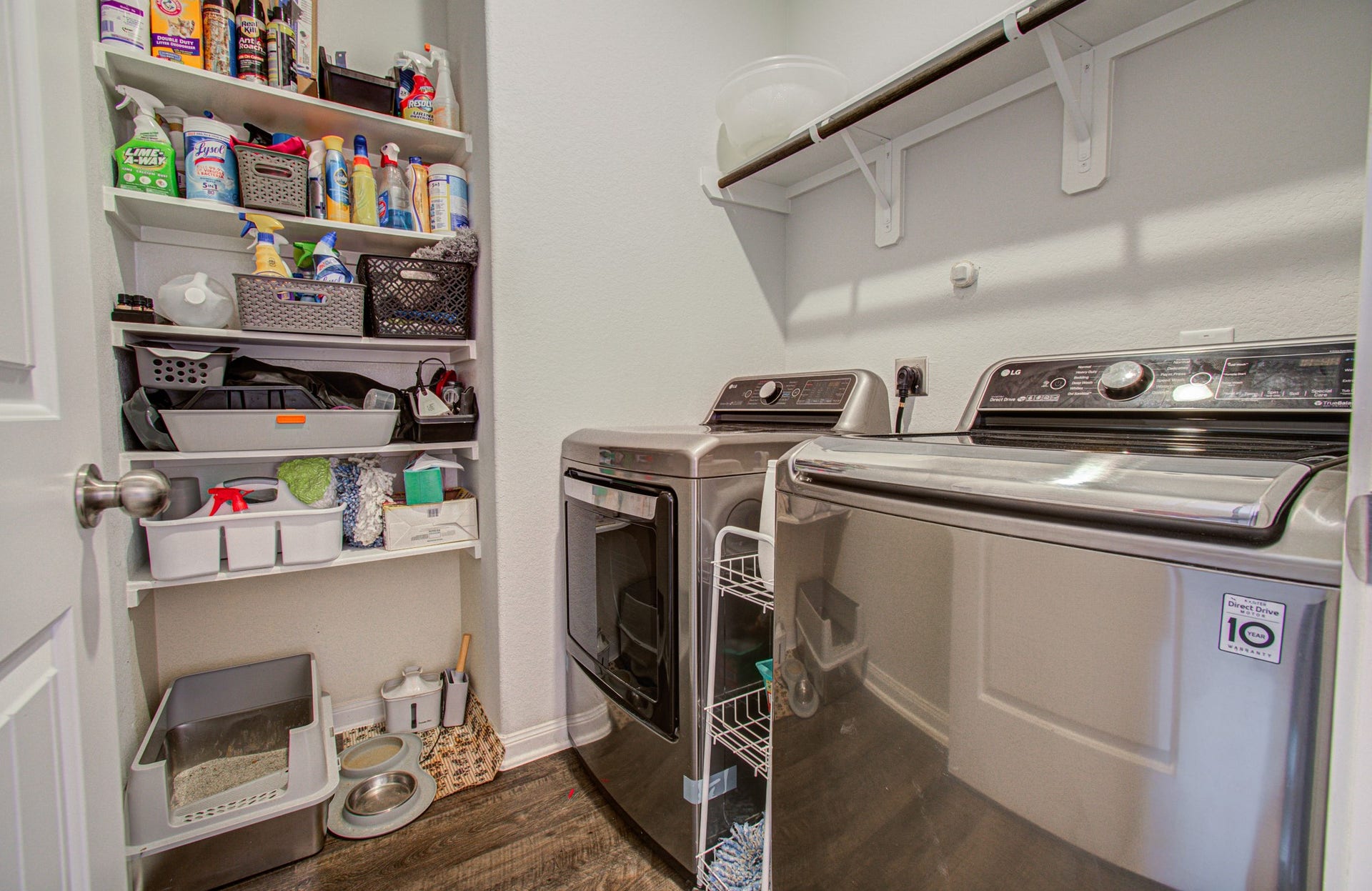 11064 Patriot Court, Cleveland, TX 77328 Modern laundry room featuring sleek stainless steel washer and dryer, ample shelving for storage, and a convenient layout for organization.