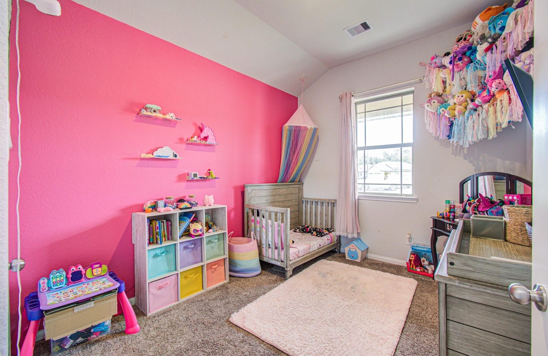 11064 Patriot Court, Cleveland, TX 77328 Charming and vibrant bedroom with a bright pink accent wall, and ample natural light..