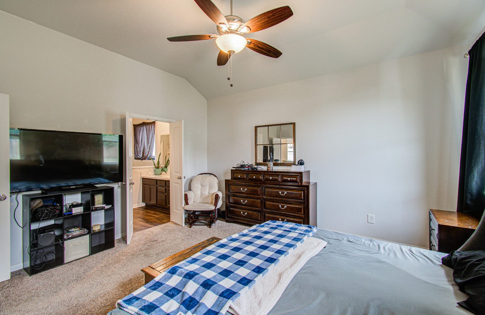11064 Patriot Court, Cleveland, TX 77328 Spacious primary bedroom featuring a ceiling fan,with direct access to an en-suite bathroom.