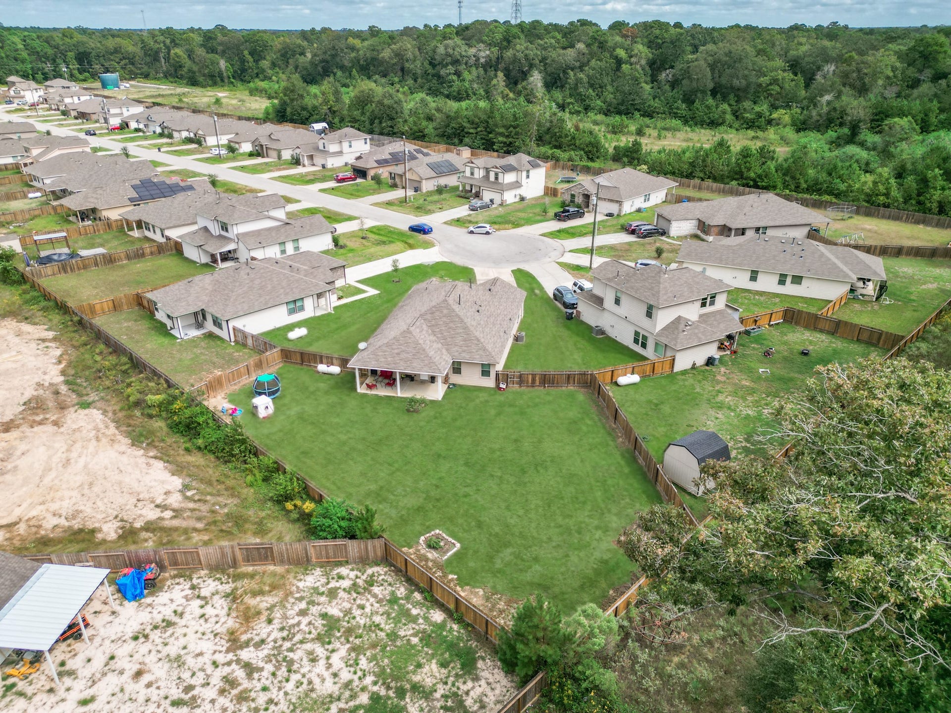 11064 Patriot Court, Cleveland, TX 77328 Charming neighborhood with well-maintained homes, spacious fenced yards, and a serene backdrop of lush greenery, perfect for family living.