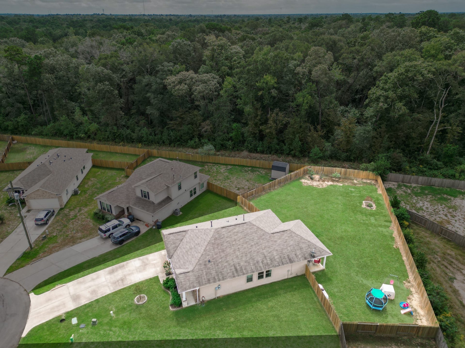 11064 Patriot Court, Cleveland, TX 77328 Charming home nestled at the end of a cul-de-sac, featuring a spacious backyard with lush greenery and privacy fencing, perfect for outdoor activities and relaxation.