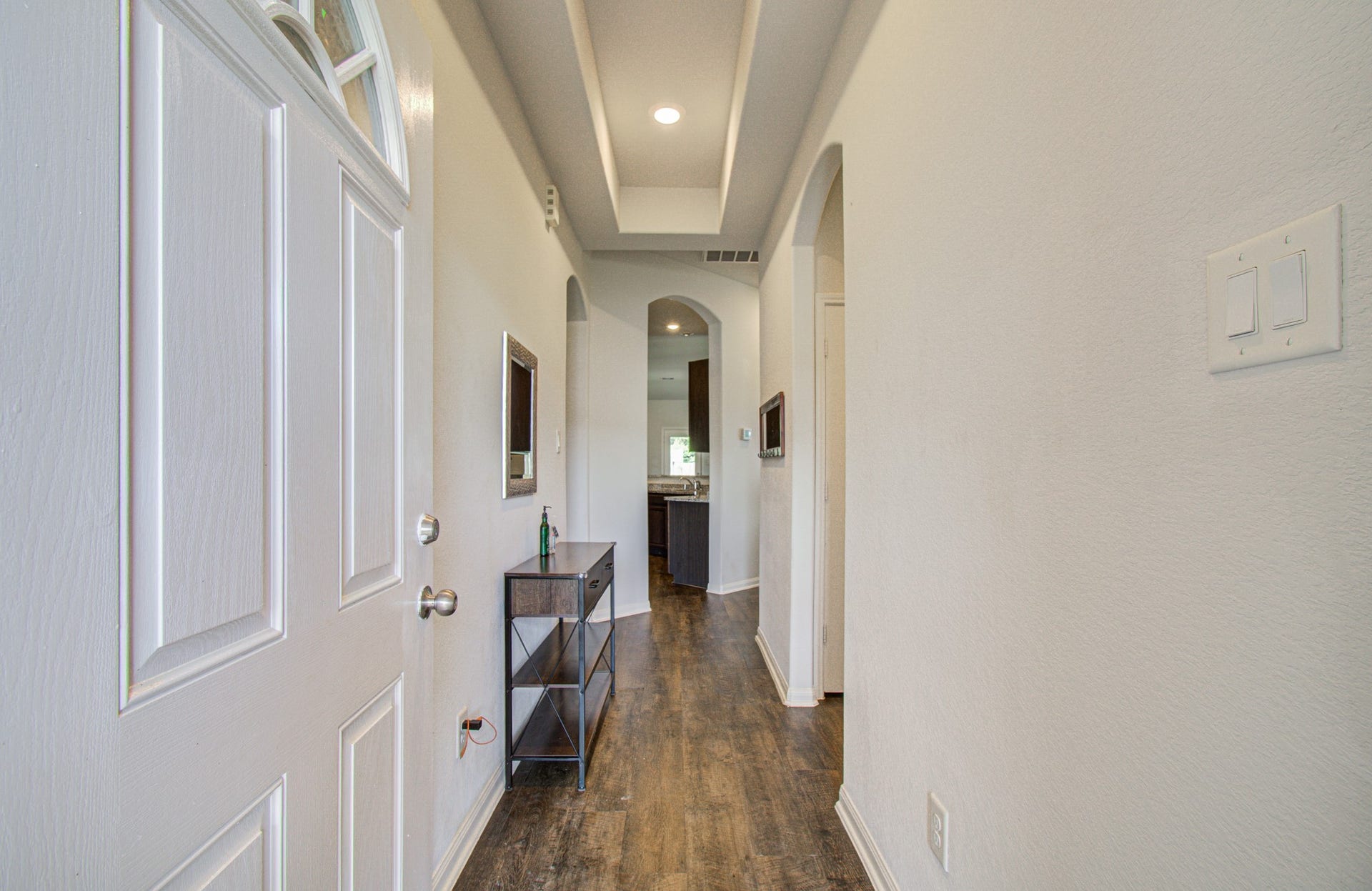 11064 Patriot Court, Cleveland, TX 77328 Inviting entryway with elegant archways, recessed lighting, and stylish wood flooring leading to the main living area.