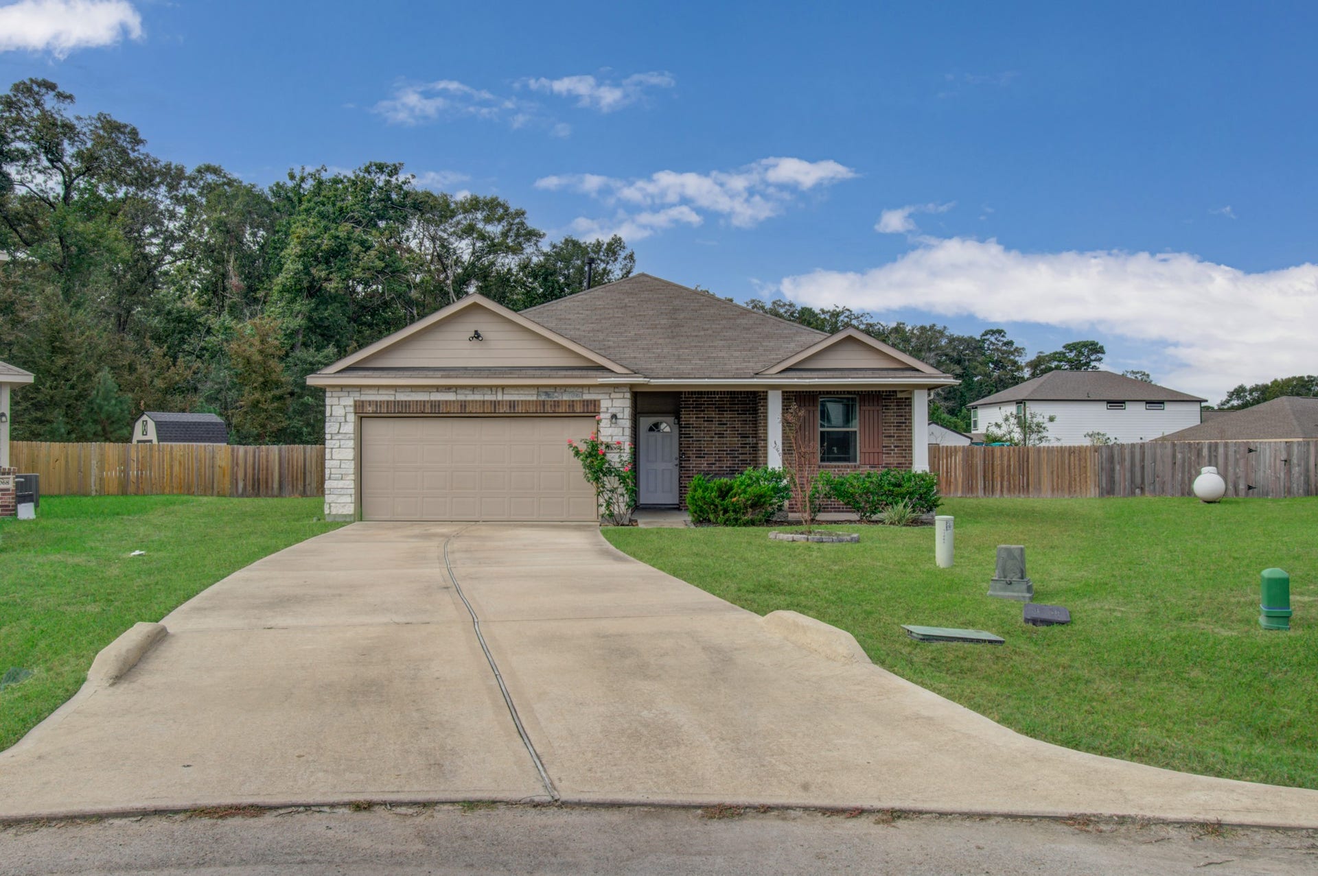 11064 Patriot Court, Cleveland, TX 77328 Charming single-story home with a welcoming front porch, spacious driveway, and a two-car garage, set on a generous lawn with a fenced backyard.