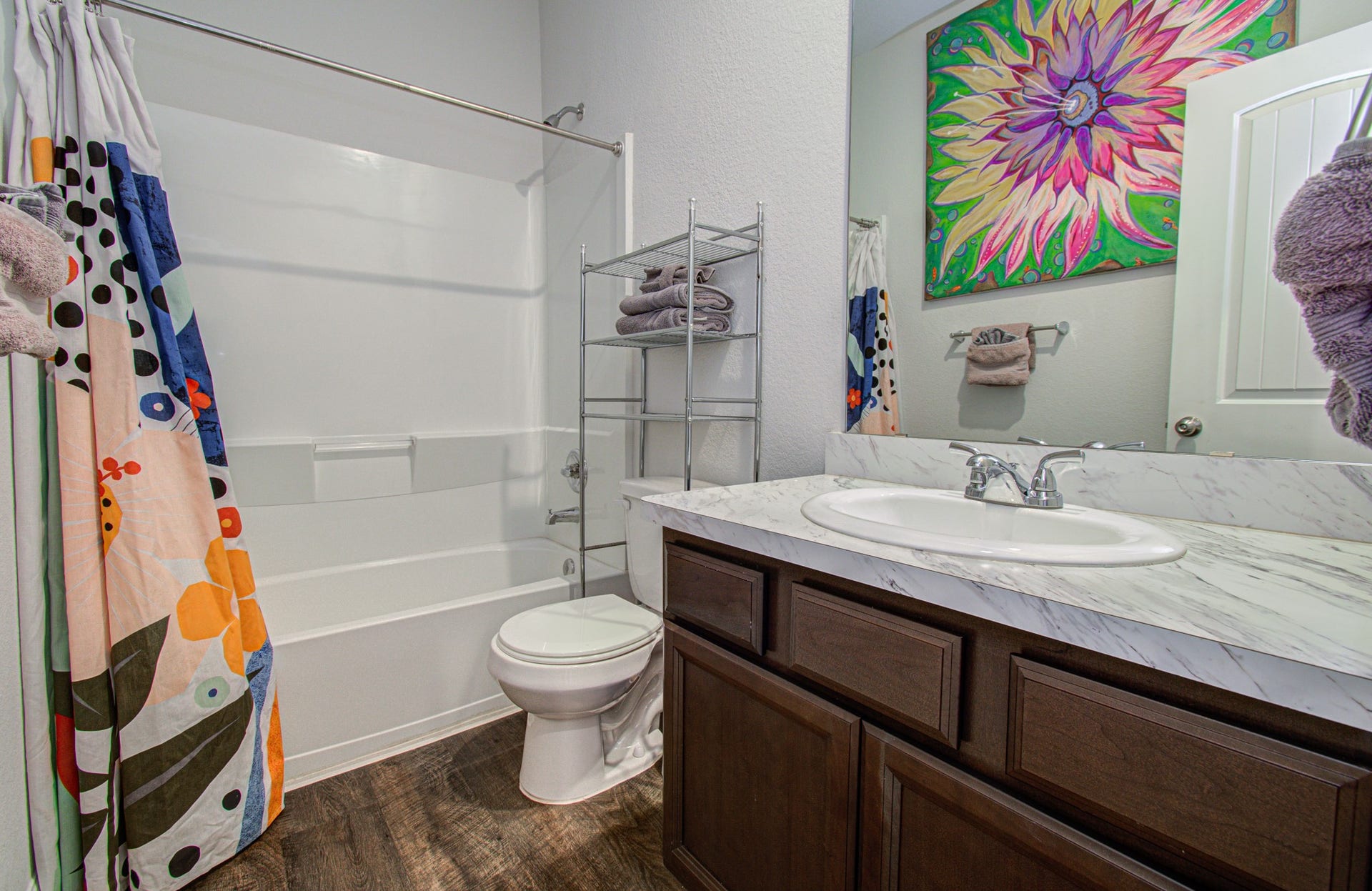 11064 Patriot Court, Cleveland, TX 77328 Bright secondary bathroom with a modern vanity, marble countertop, and vibrant decor.