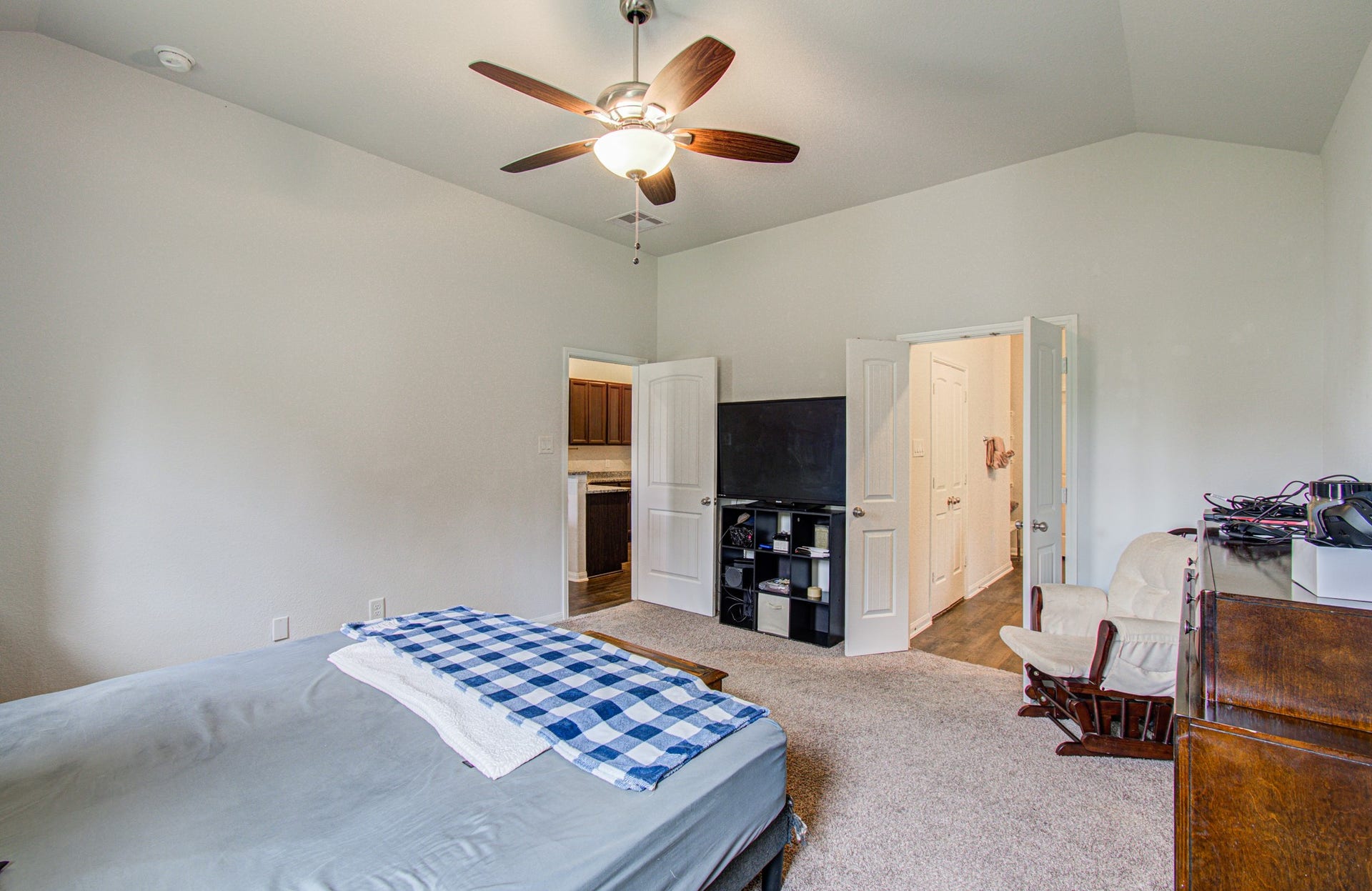 11064 Patriot Court, Cleveland, TX 77328 Spacious primary bedroom, featuring a ceiling fan and ample natural light. The room includes convenient access to adjacent areas and offers versatile space for furnishings.