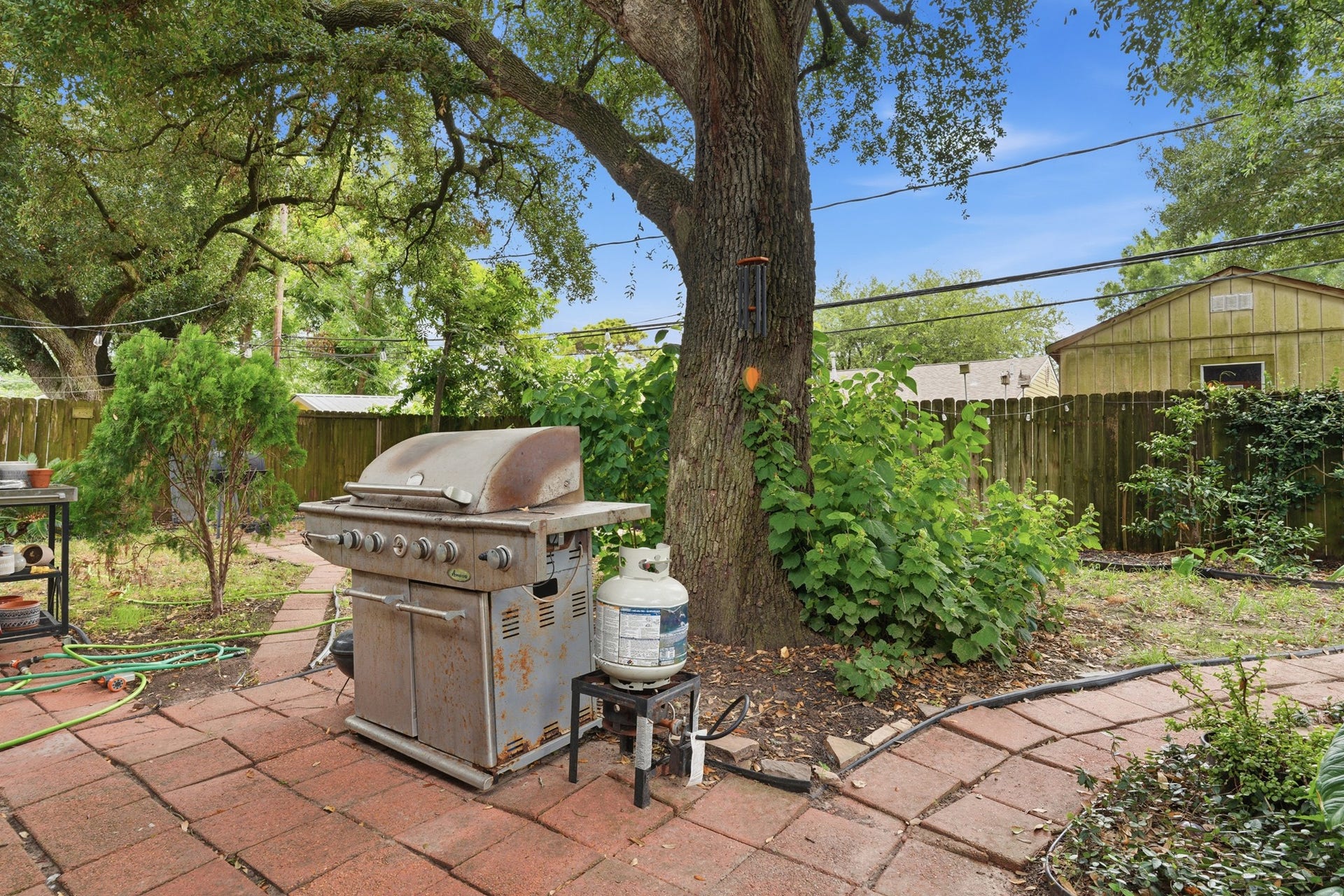 2216 Peach Lane, Pasadena, TX 77502 Enjoy outdoor gatherings in this charming backyard oasis, complete with a grill that stays with the home, perfect for entertaining under the shade of mature trees.