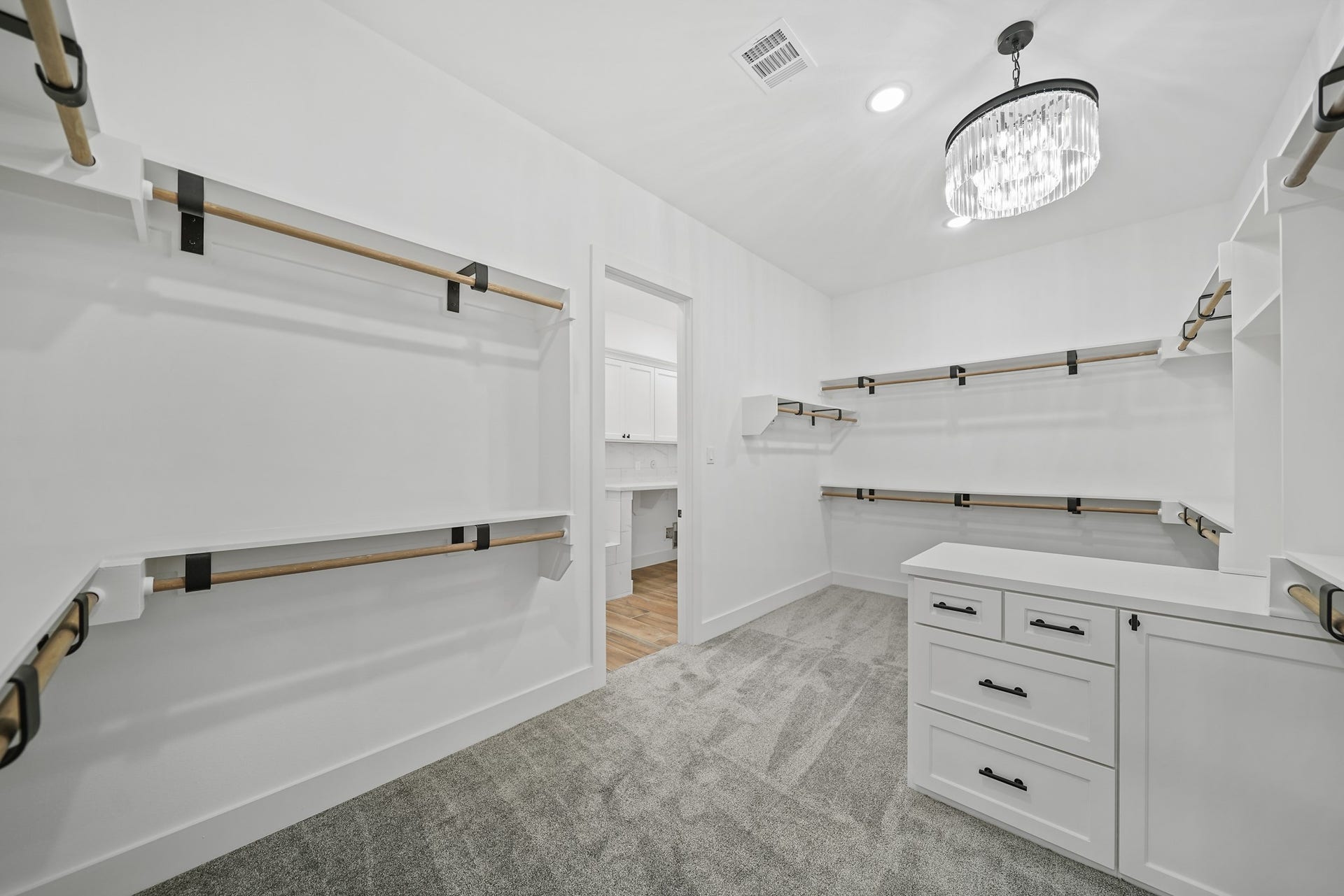 Discover unparalleled convenience in the primary closet, offering direct access to the centrally located laundry room. This access serves as a thoughtful secondary exit from the primary bedroom, providing a discreet option to slip out without disturbing your loved one on those leisurely sleep-in mornings. Experience seamless living with this cleverly designed space, ensuring both functionality and consideration for peaceful moments.