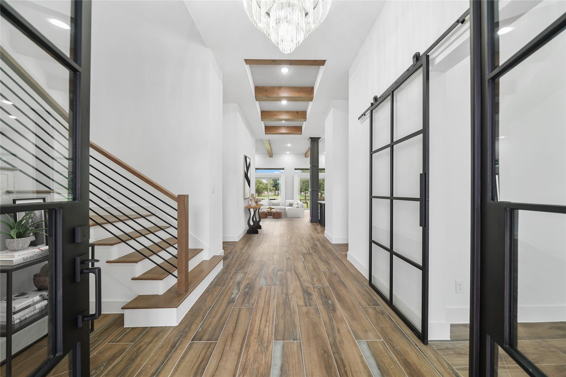 Stroll through the oversized hallway adorned with designer flooring, custom woodwork and upgraded light fixtures seamlessly linking every corner of this remarkable home. To the right, a sleek steel barn door opens to reveal your private study. Virtually staged.