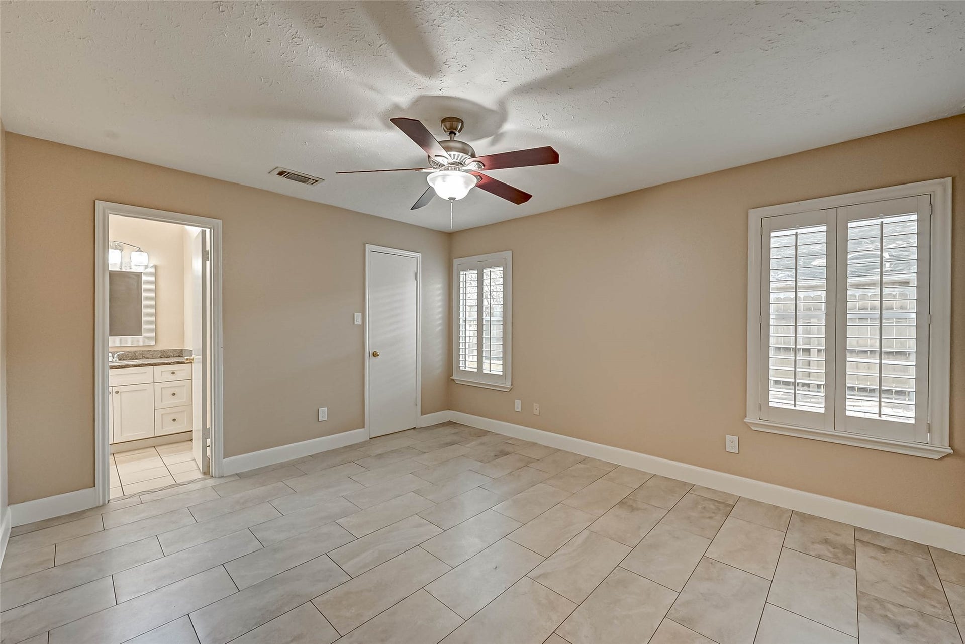 3510 Greenwood Dr Drive, Sugar Land, TX 77478 The prmary bedroom is located downstairs with plantation shutters and a great ceiling fan.