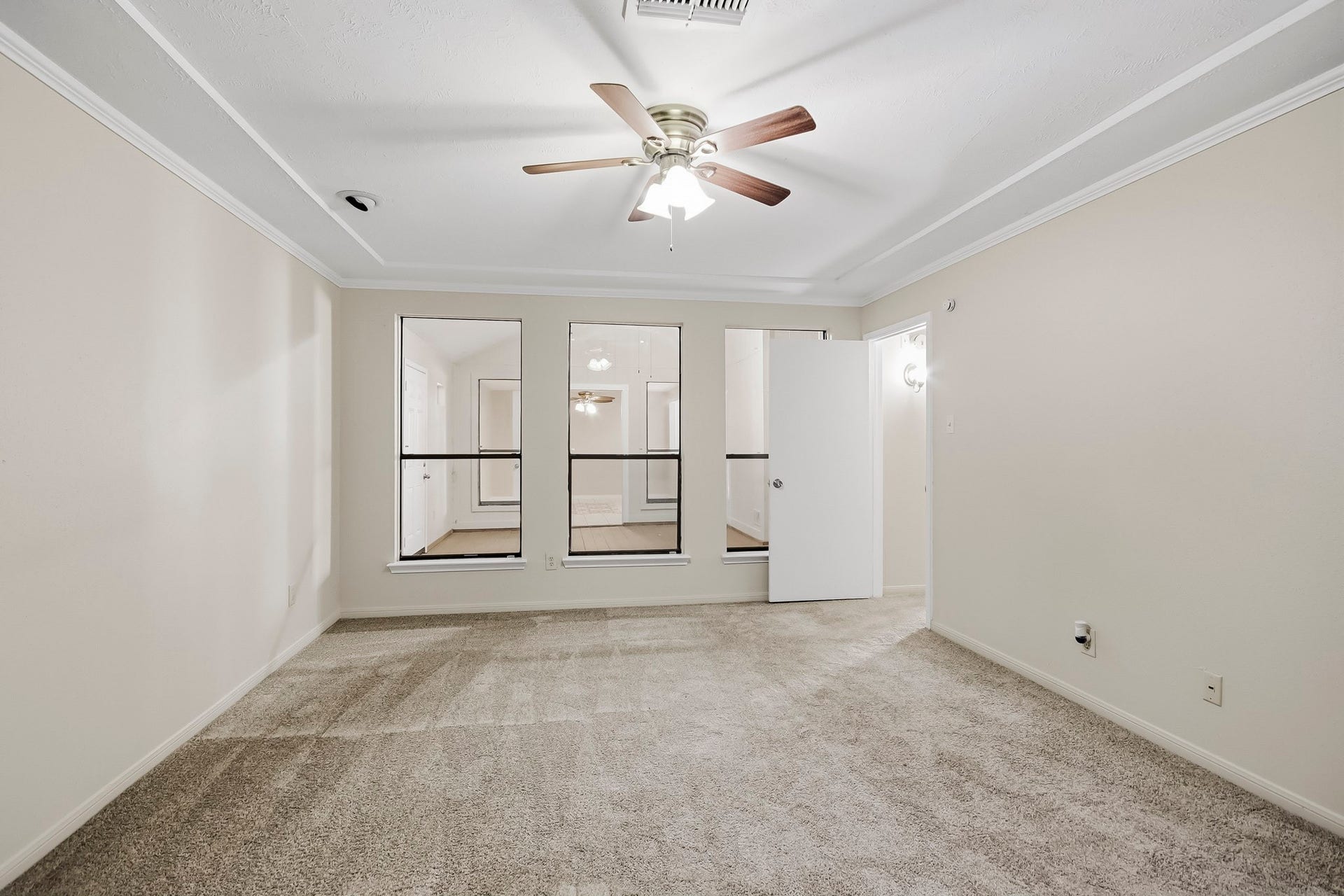 8807 Lakeside Forest Drive, Houston, TX 77088 Another view of the spacious primary bedroom, featuring a tray ceiling, access to ensuite bathroom, and a view of the adjoining flex space.