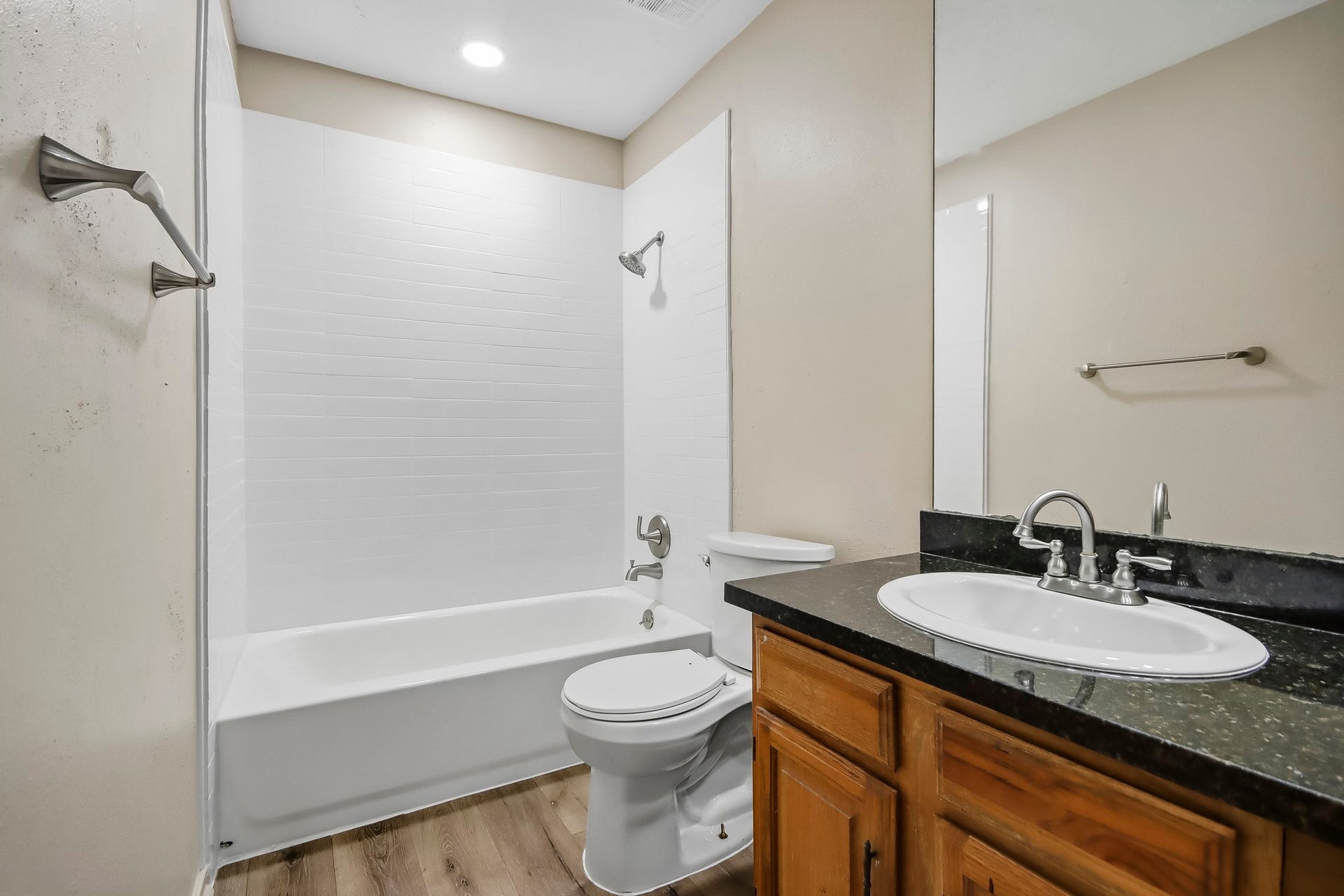 8807 Lakeside Forest Drive, Houston, TX 77088 Shared bathroom featuring a tub and shower combination, single vanity, and wood-look flooring.