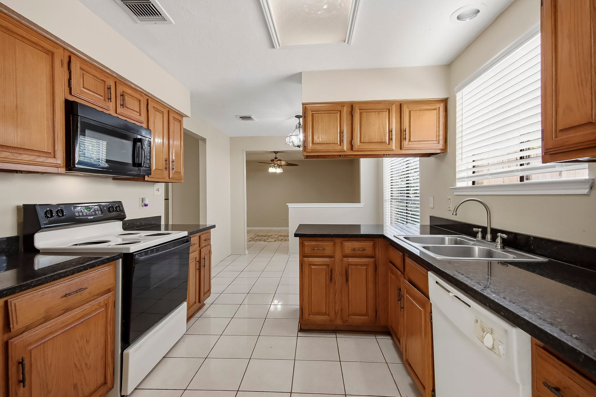 8807 Lakeside Forest Drive, Houston, TX 77088 Another view of the kitchen, featuring ample cabinet space, a breakfast bar, and an opening to the adjoining living area.