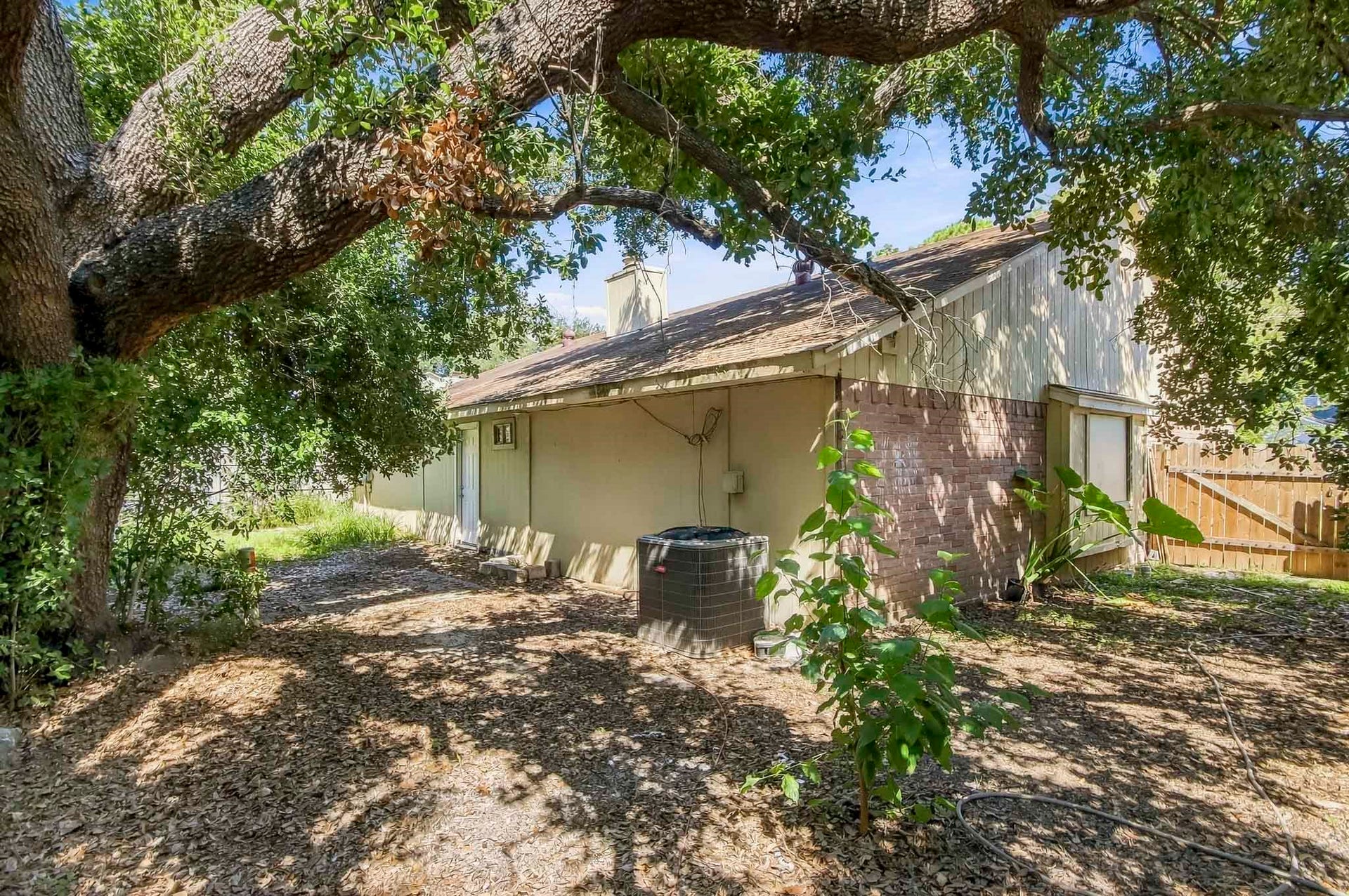 8807 Lakeside Forest Drive, Houston, TX 77088 Side view of the home featuring mature trees providing plenty of shade and access to the backyard.