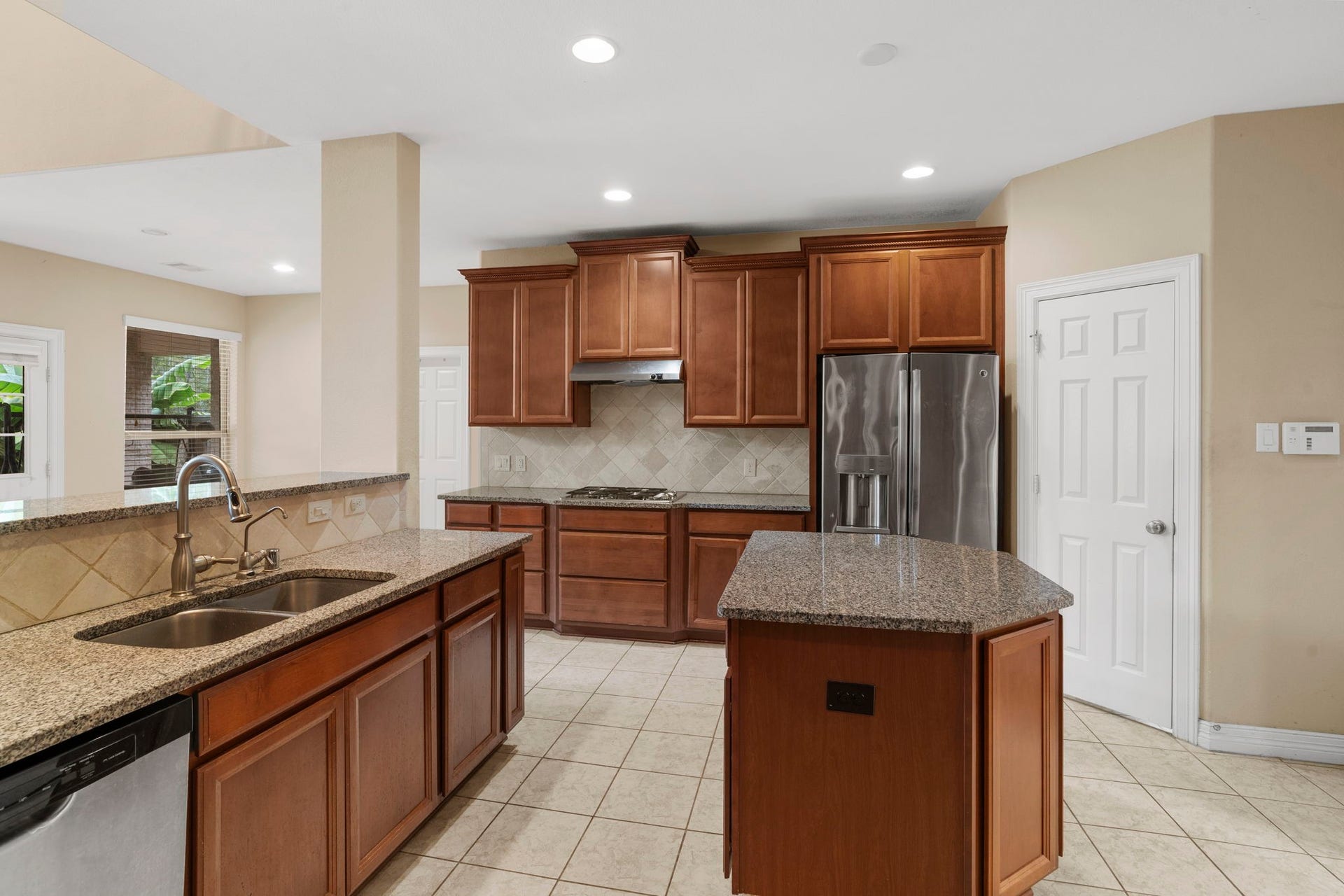 5515 Mangrove Creek Lane, Sugar Land, TX 77479 Durable granite countertops pair beautifully with a travertine tile backsplash and stainless steel appliances.